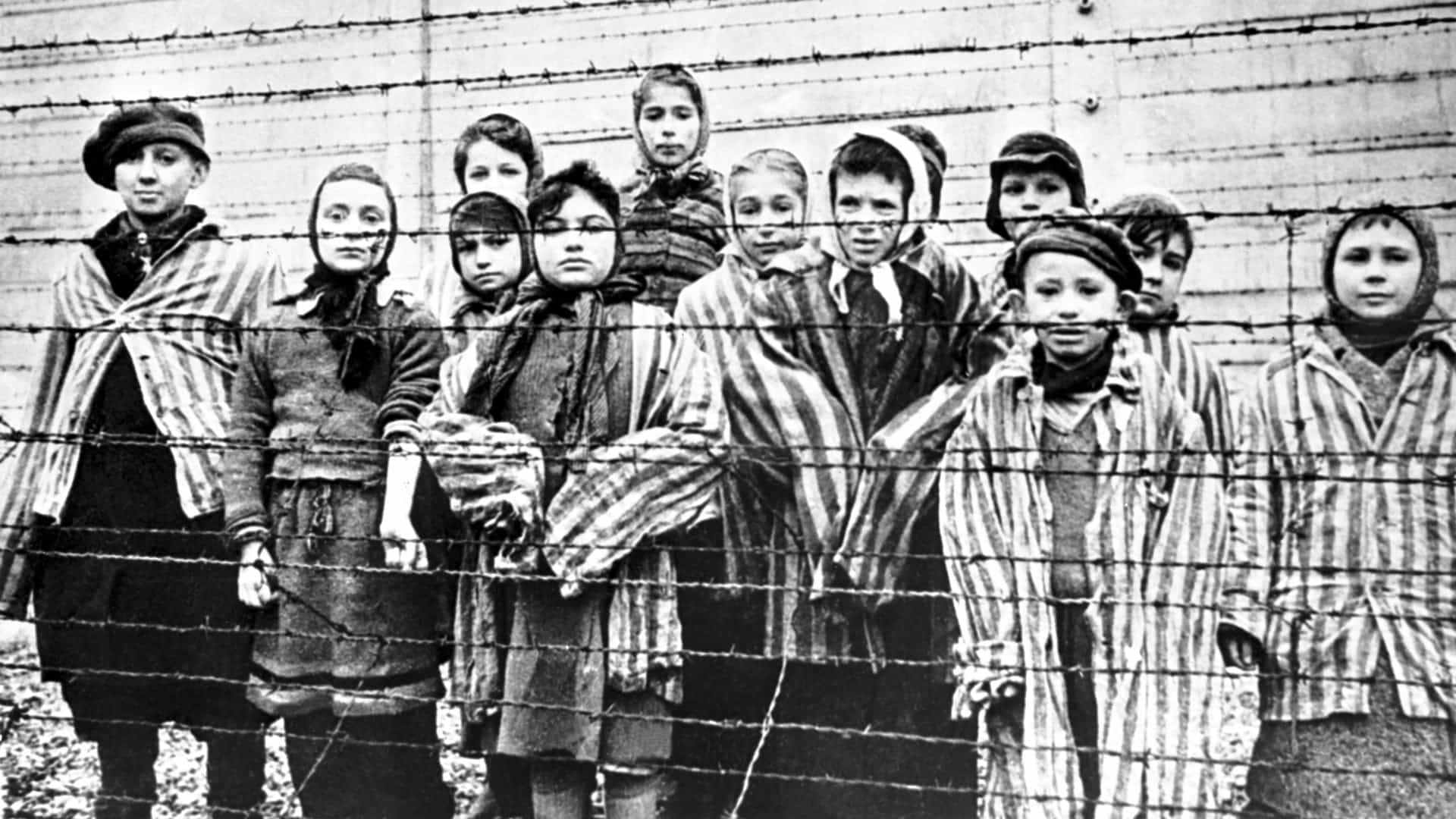 A group of child survivors behind a barbed wire fence at the Nazi concentration camp at Auschwitz-Birkenau in southern Poland, on the day of the camp’s liberation by the Red Army, 27th January 1945.