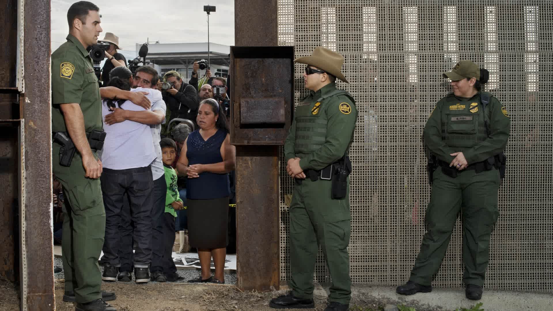 Border-patrol agents guarding the U.S. side of the Mexican border at San Diego open the gate to let six families unite and hug for three minutes each before closing the gate again. The event is organized by Border Angels, a migrant-advocacy group.