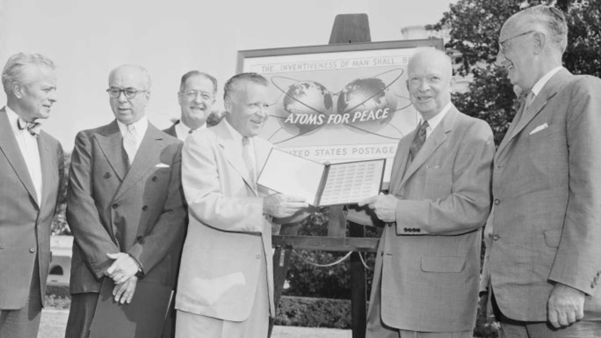 President Eisenhower receiving the commemorative stamp made in honor of his program, "Atoms for Peace." (Credit: Bettmann Archive/Getty Images)