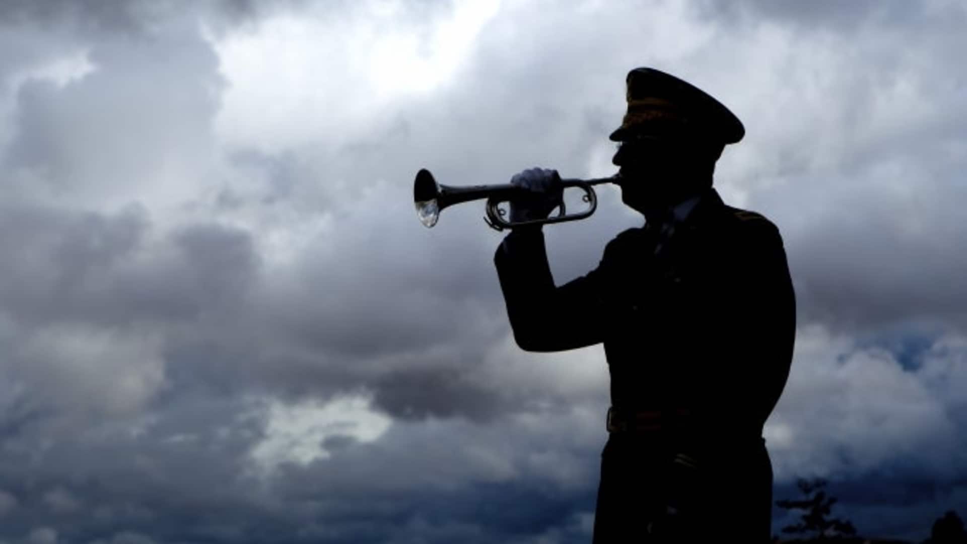 Silhouette of a man playing taps on his bugle. (Credit: gjohnstonphoto/istockphoto.com)