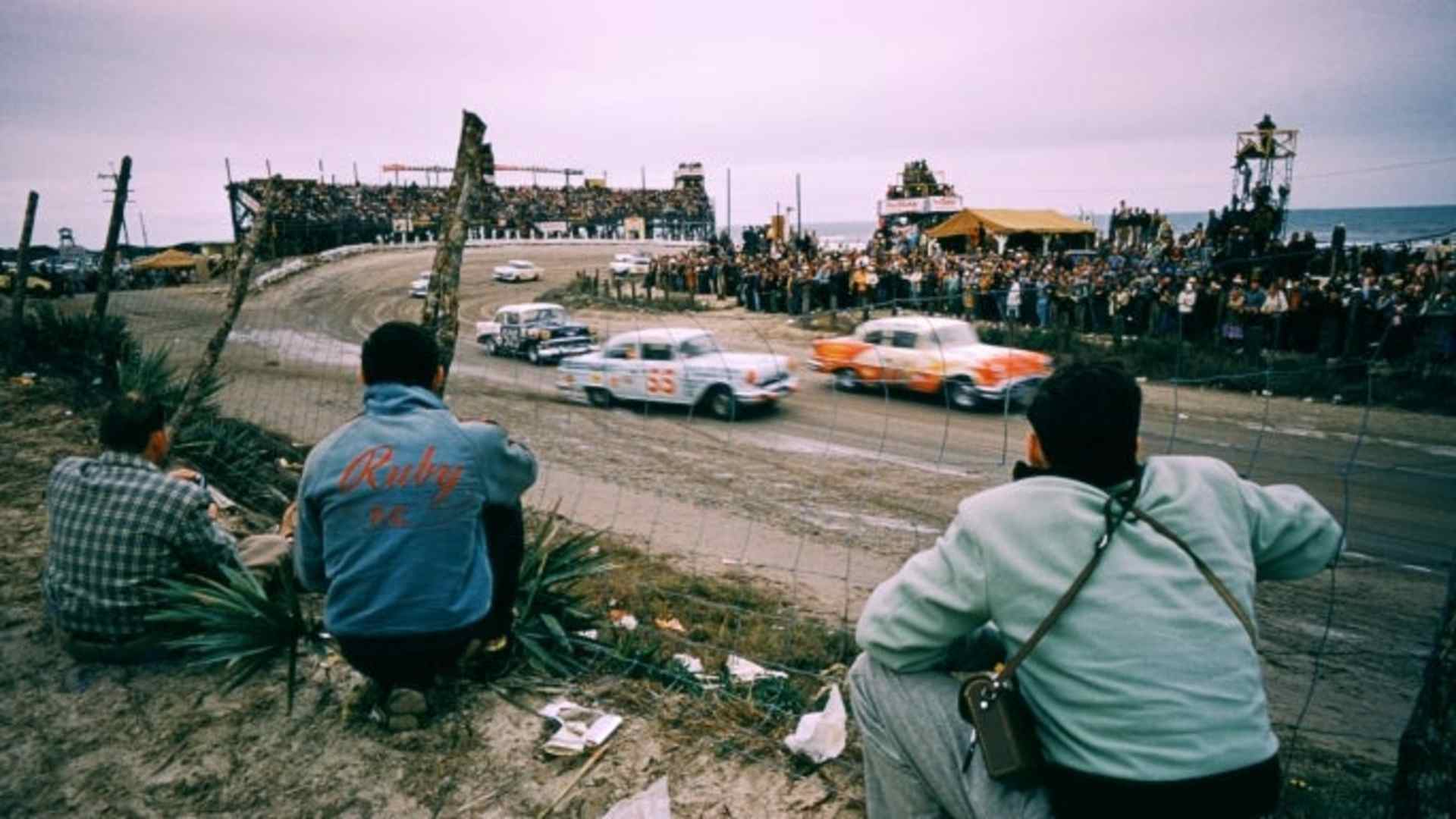 Junior Johnson in the Pontiac #55 car and Charlie Cregar in the Chevrolet #505 car race as fans watch the action at Daytona Beach, 1956. NASCAR has grown from moonshine runners escaping federal agents to one of the most popular sports in the country. (Credit: Hy Peskin/Getty Images)