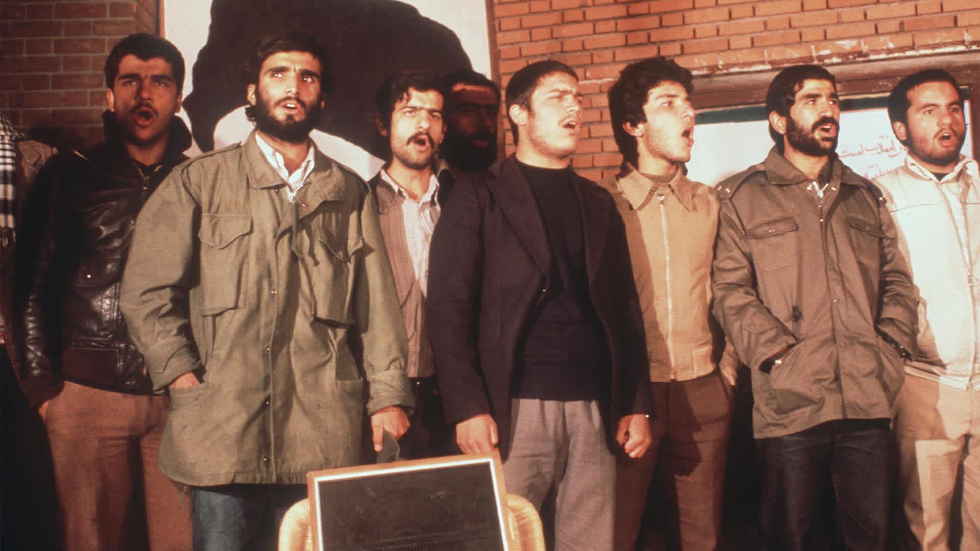 The Iranian students, who have occupied the U.S EmTEHRAN, IRAN - NOVEMBER 19: The Iranian students, who have occupied the U.S Embassy in Tehran, are singing during the second released group of U.S. Embassy staffers hold a press conference 19 November 1979, two days after Ayatollah Khomeini ordered the release of all women and black U.S. hostages. Fanatical followers of the Ayatollah Khomeini stormed the United States Embassy, 04 November 1979 in Tehran, occupied the building and took nearly 100 embassy staff and Marines hostages. (Photo credit should read H. KOTILAINEN/AFP via Getty Images)