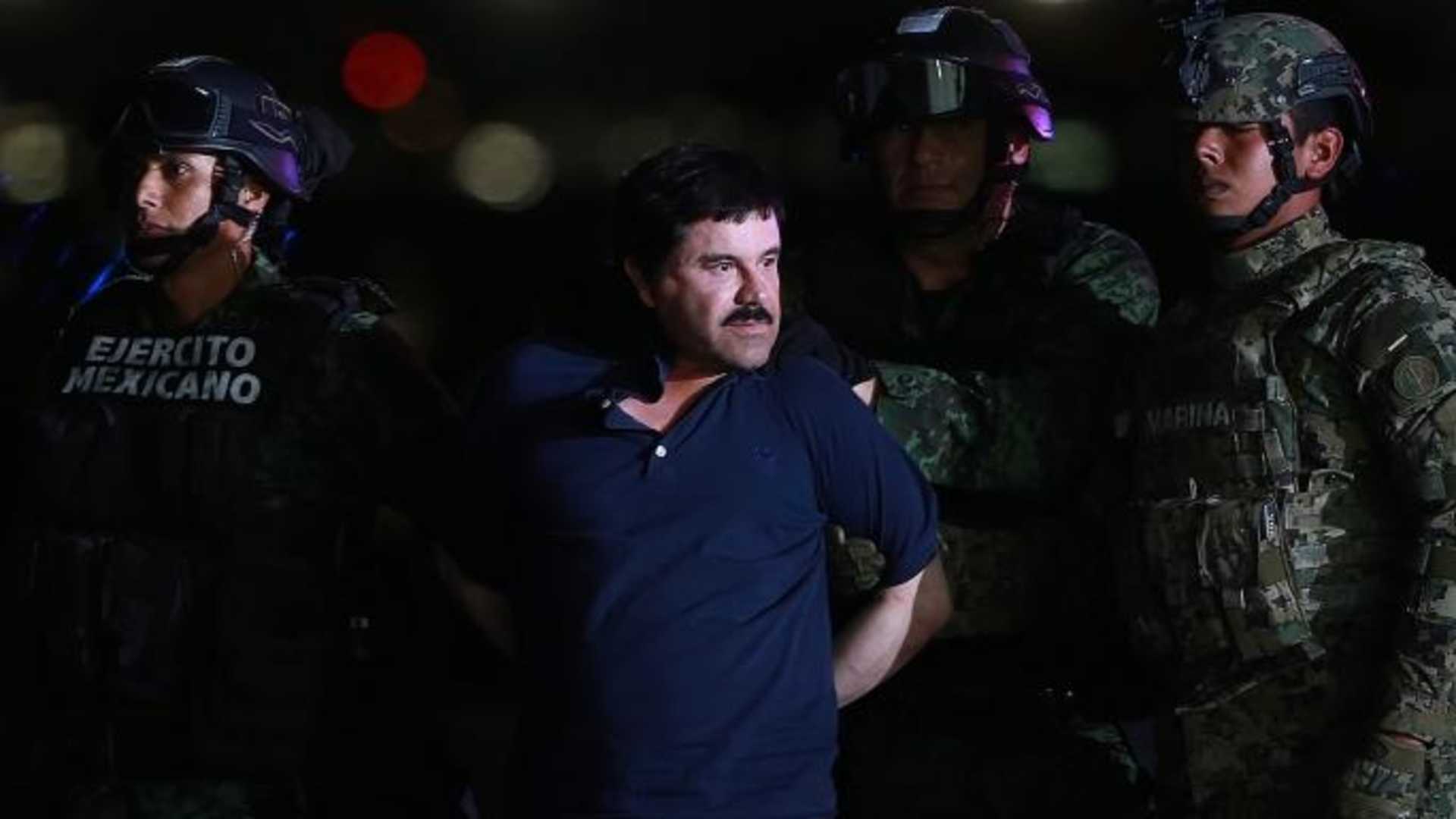 Joaquin "El Chapo" Guzman, the world's most wanted-drug trafficker, center, is escorted by Mexican security forces at a Navy hangar in Mexico City, Mexico, on Friday, Jan. 8, 2016. (Credit: Susana Gonzalez/Bloomberg via Getty Images)