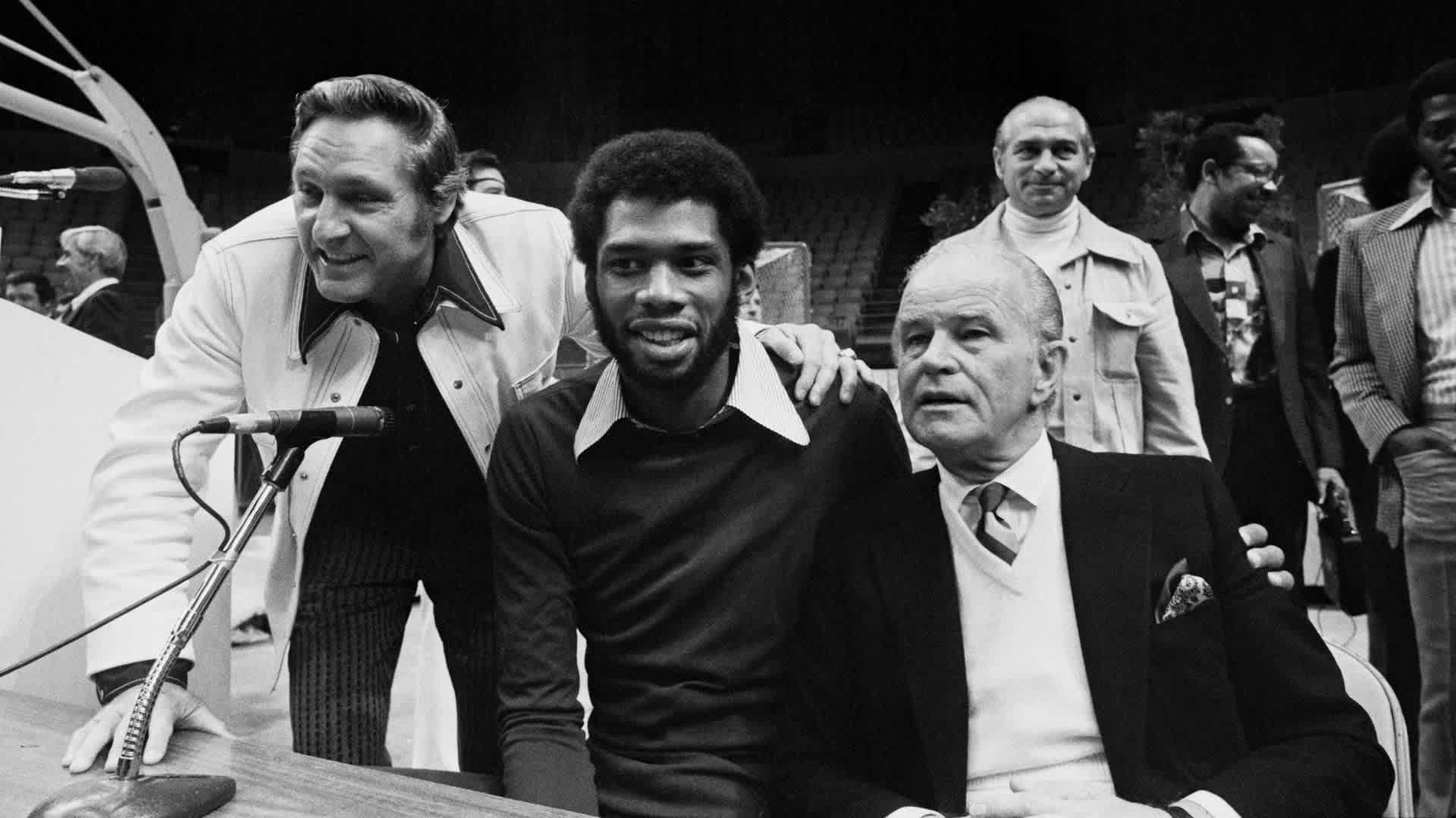 Kareem Abdul-Jabbar (center) with Lakers owner Jack Kent Cooke (right) and coach Bill Sharman in 1975. / Bettmann Archive/Getty Images