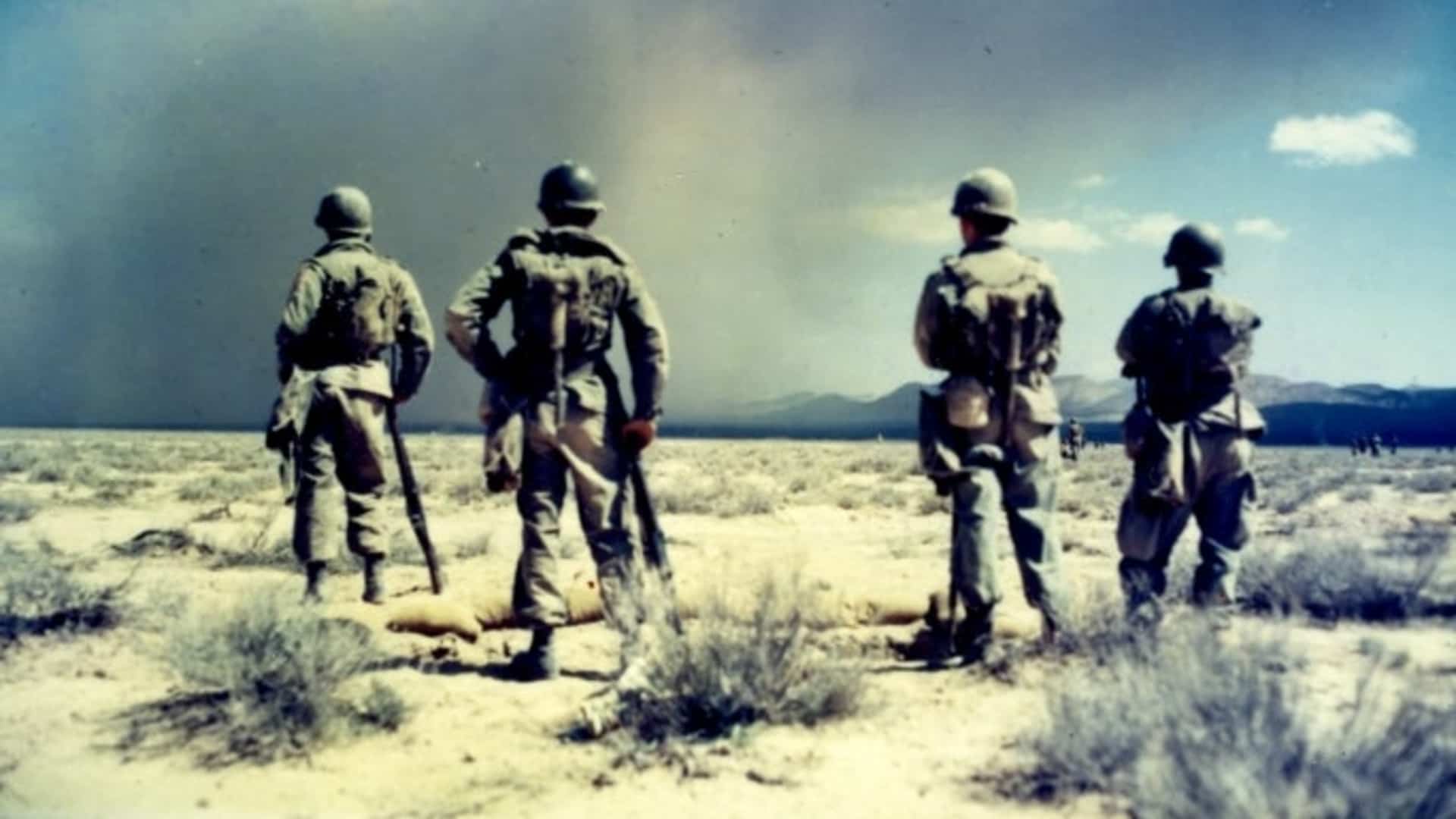 Four men from the 82nd Airborne Division looking at the base of the mushroom cloud of atomic bomb test on April 22, 1952.