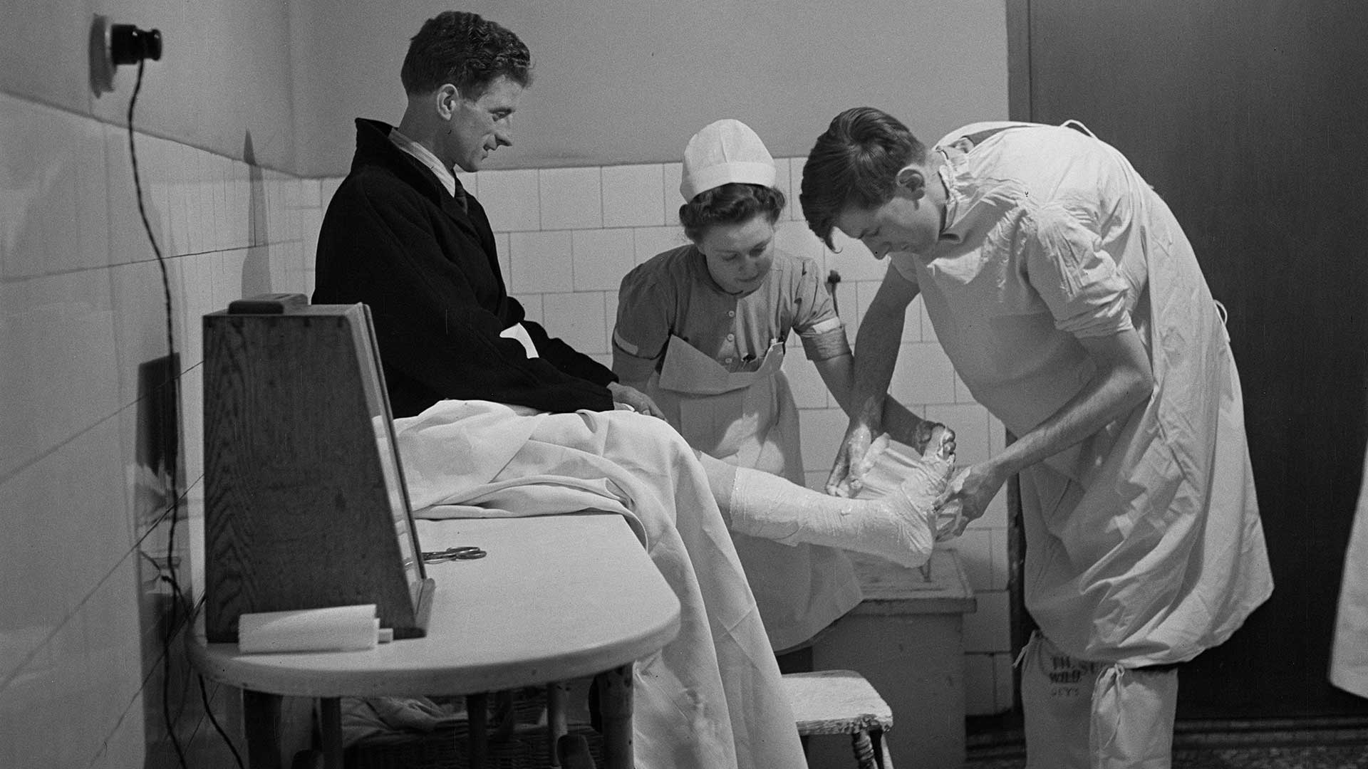 Applying a plaster cast to a patient's lower leg and foot, February 1948.