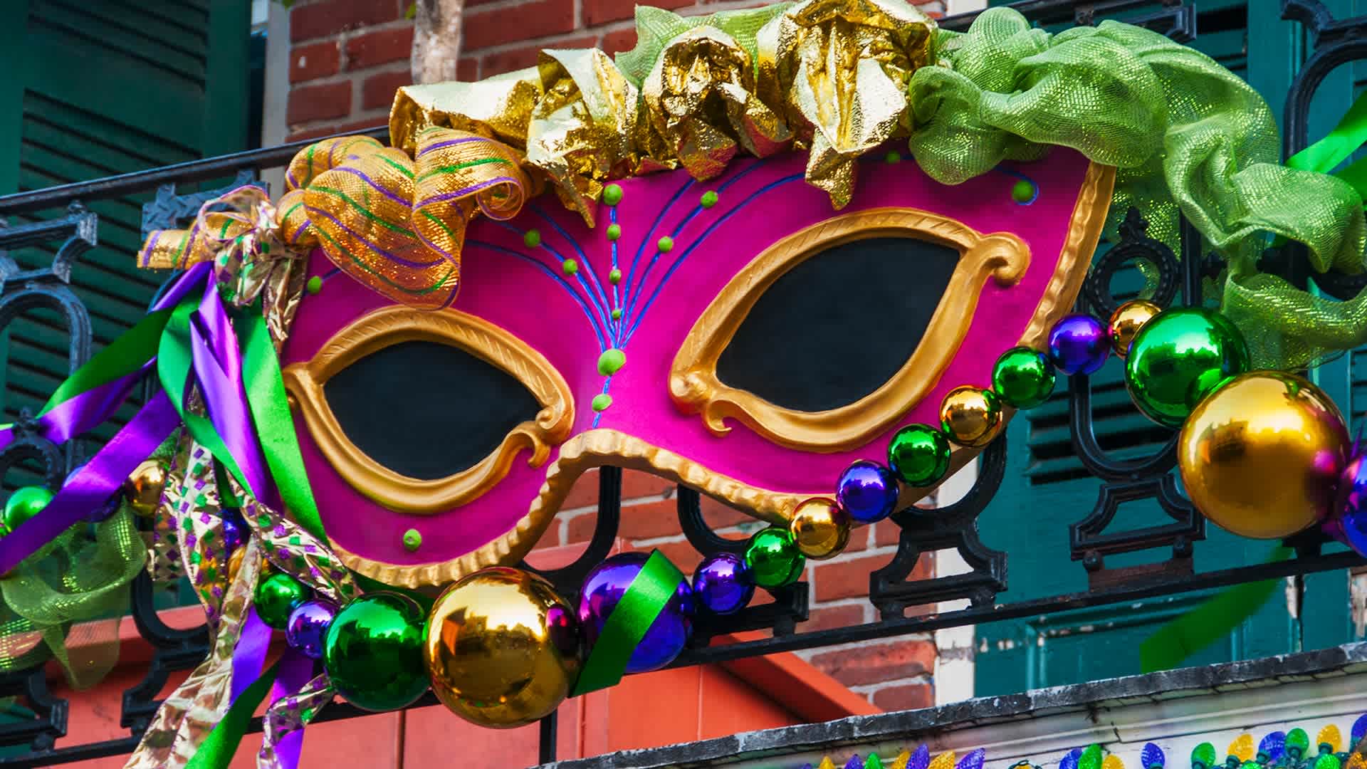 Mardi Gras mask hanging on balcony's railing in New Orleans, Louisiana.