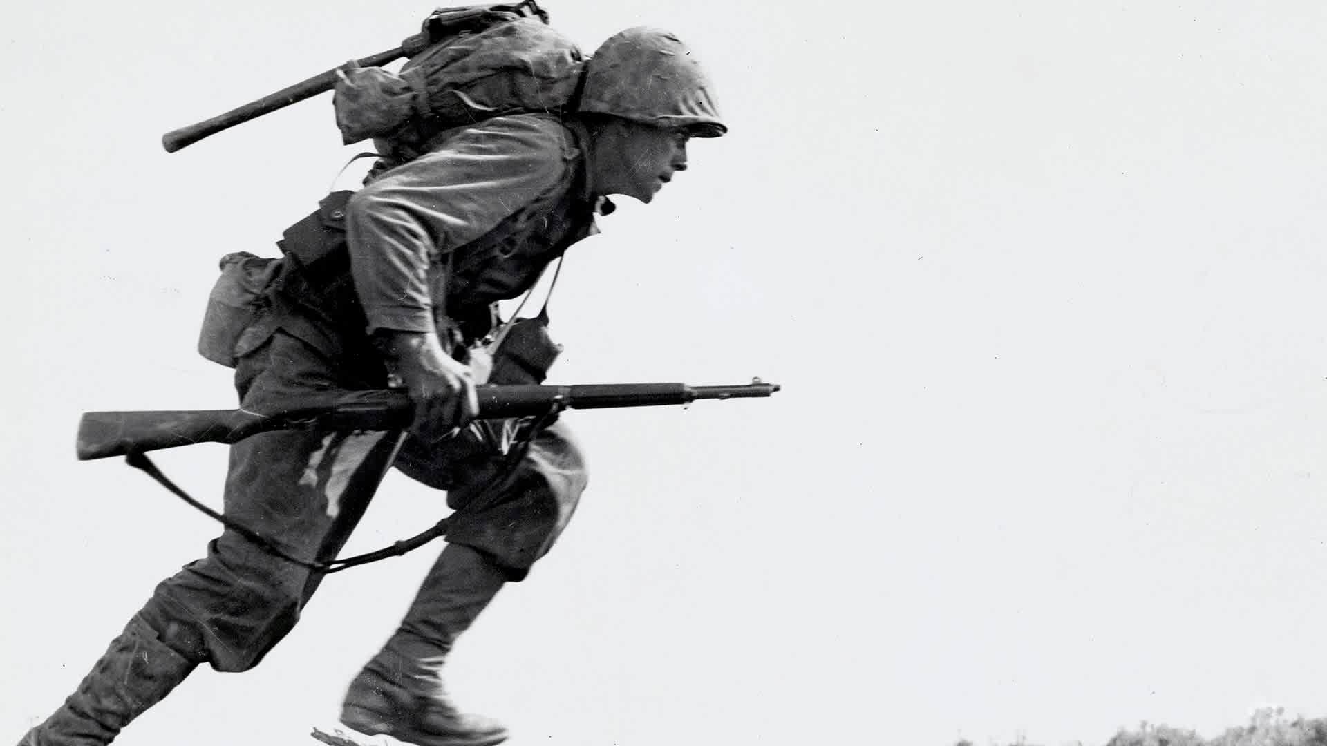 A marine rises from one position in a valley, later named Death Valley, to find a new position. Over 125 marines lost their lives in eight hours crossing this valley on Okinawa.
