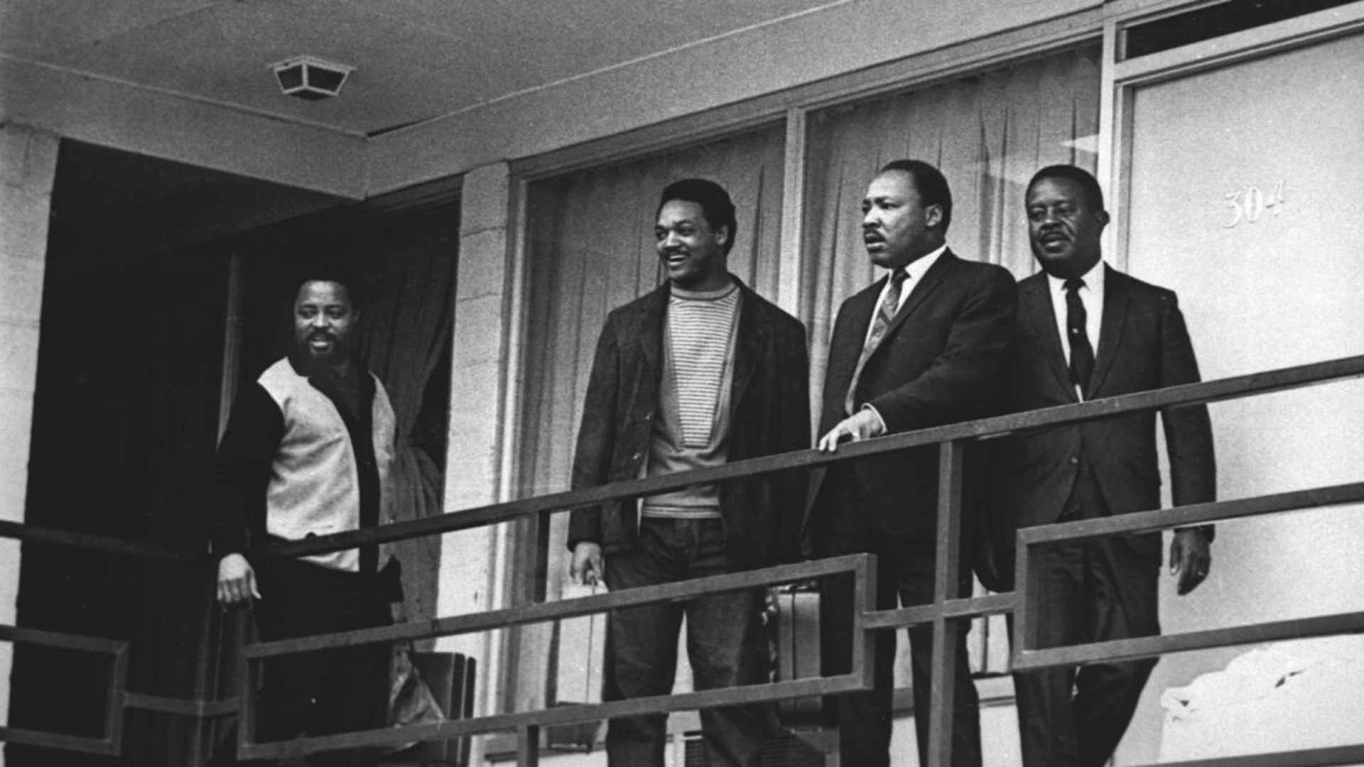 Martin Luther King, Jr. standing  with Hosea Williams, Jesse Jackson and Ralph Abernathy on April 3, 1968, on the Lorraine Motel balcony approximately in the same spot where he would be assassinated the following day. (Credit: Charles Kelly/AP Photo)
