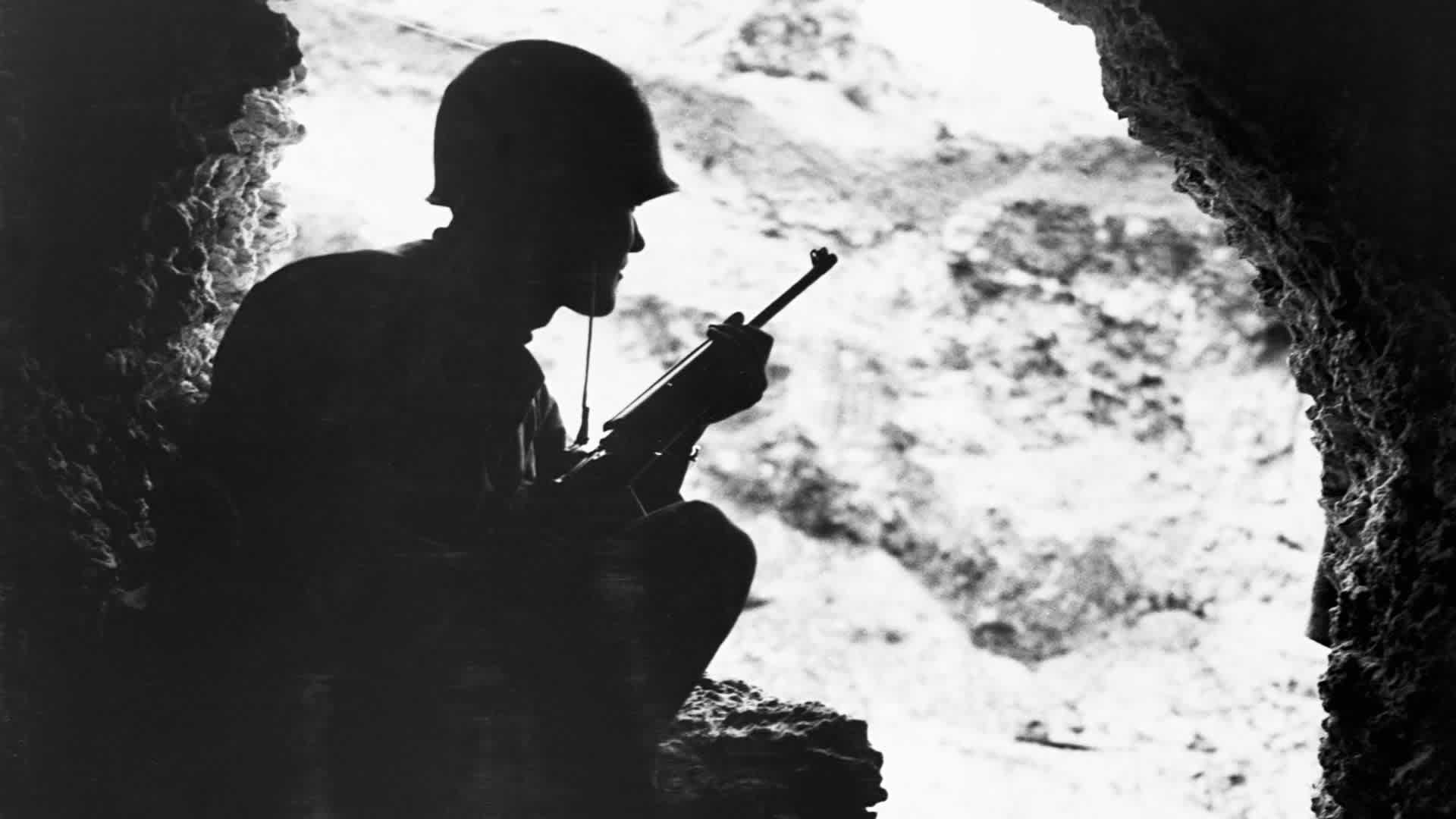 Okinawa hills, a Marine rifleman resorts to cat-and-mouse tactics to pick off enemy snipers in the surrounding ridges, June 1945