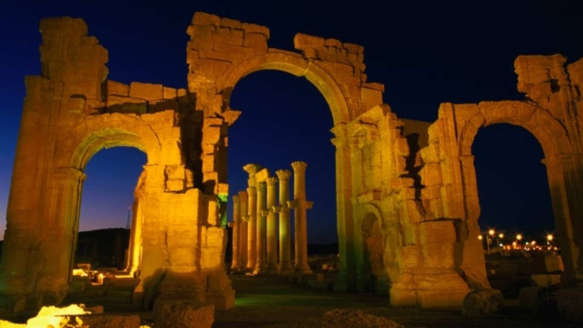 Floodlit monumental arch marking the entrance to Palmyra. (Credit: Mark Daffey / Getty Images)