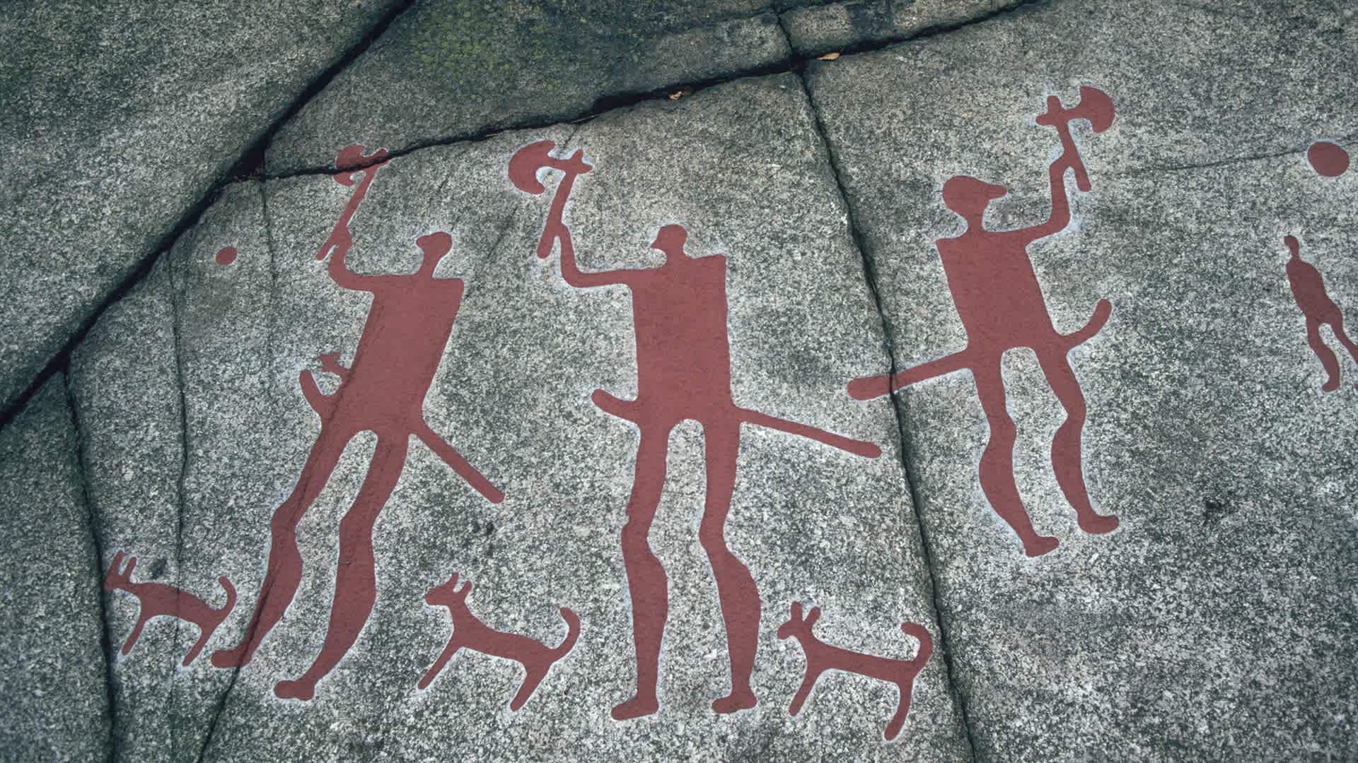 A prehistoric petroglyph at a Bronze Age site in Tanum, Bohuslan, Sweden, depicting three figures wielding axes.