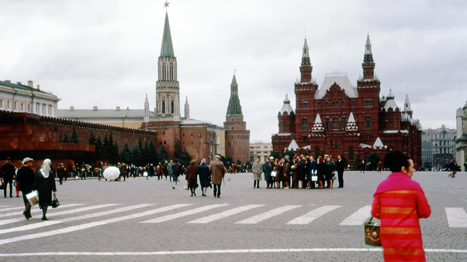 A woman in a bright coat walks among the crowds in Red Square near the State Historical Museum, in Moscow, Russia, 1973.
