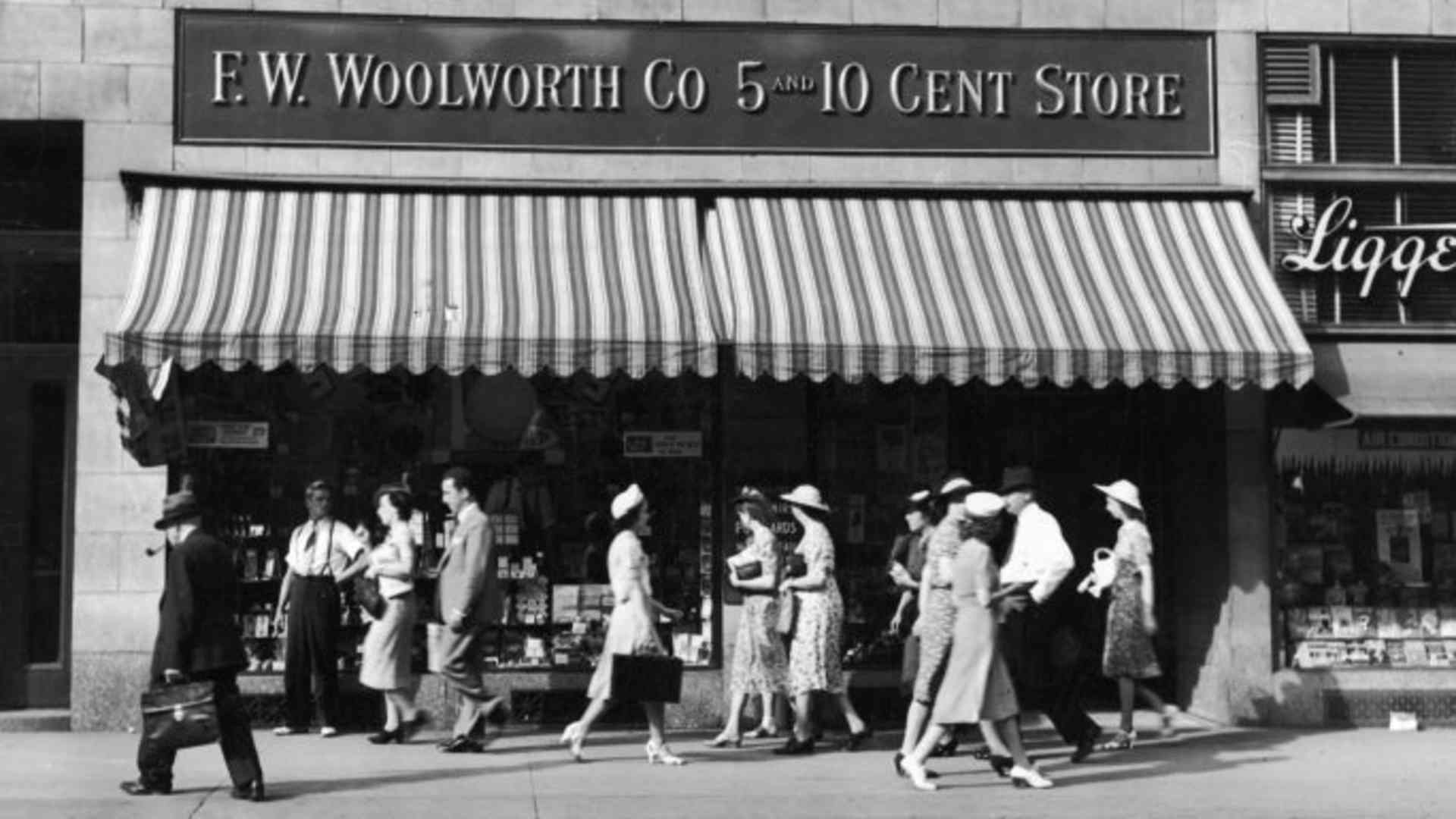 People walk past an F.W. Woolworth five and dime store on a city street, 1940s.