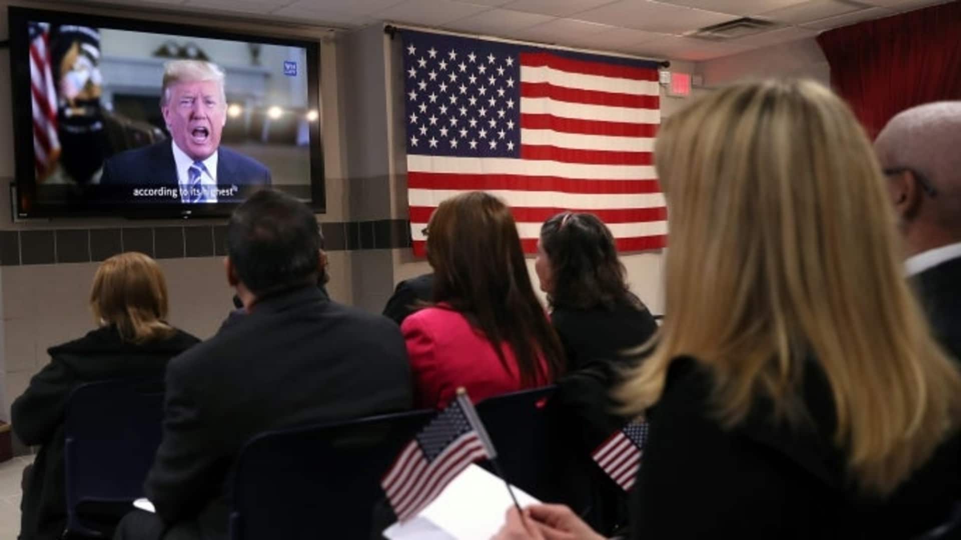 New American citizens watch a congratulatory video from President Trump at a naturalization ceremony in February, 2018 in New York City. (Credit: John Moore/Getty Images)