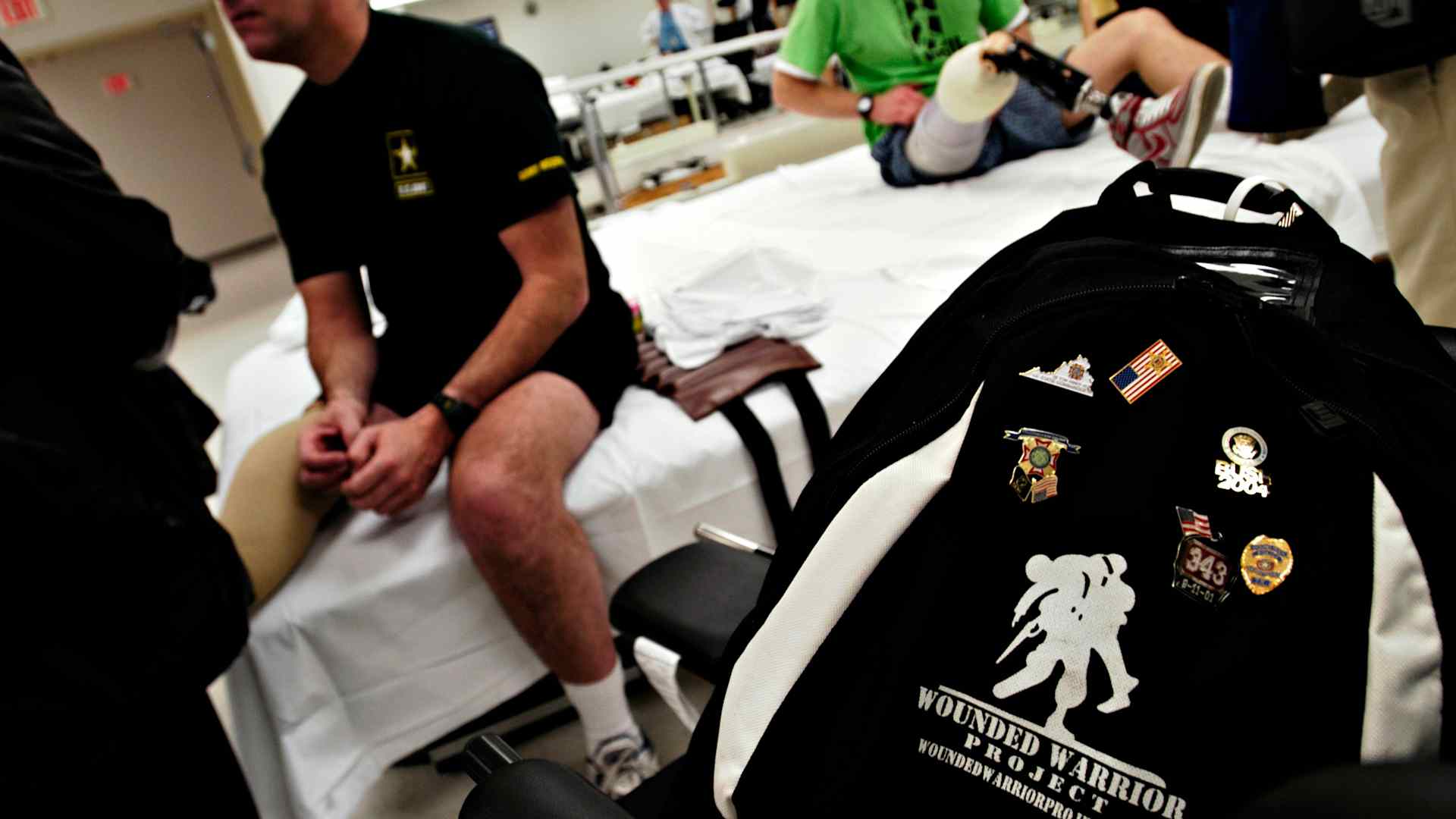 January 2005: Army Reserve Staff Sgt. Joe Bowser's "Wounded Warrior Project" backpack sits in the seat of his wheelchair in the physical therapy ward of Walter Reed Army Medical Center in Washington, D.C. as members of the Disabled American Veterans visit wounded soldiers who have recently returned from Iraq and are now receiving treatment.