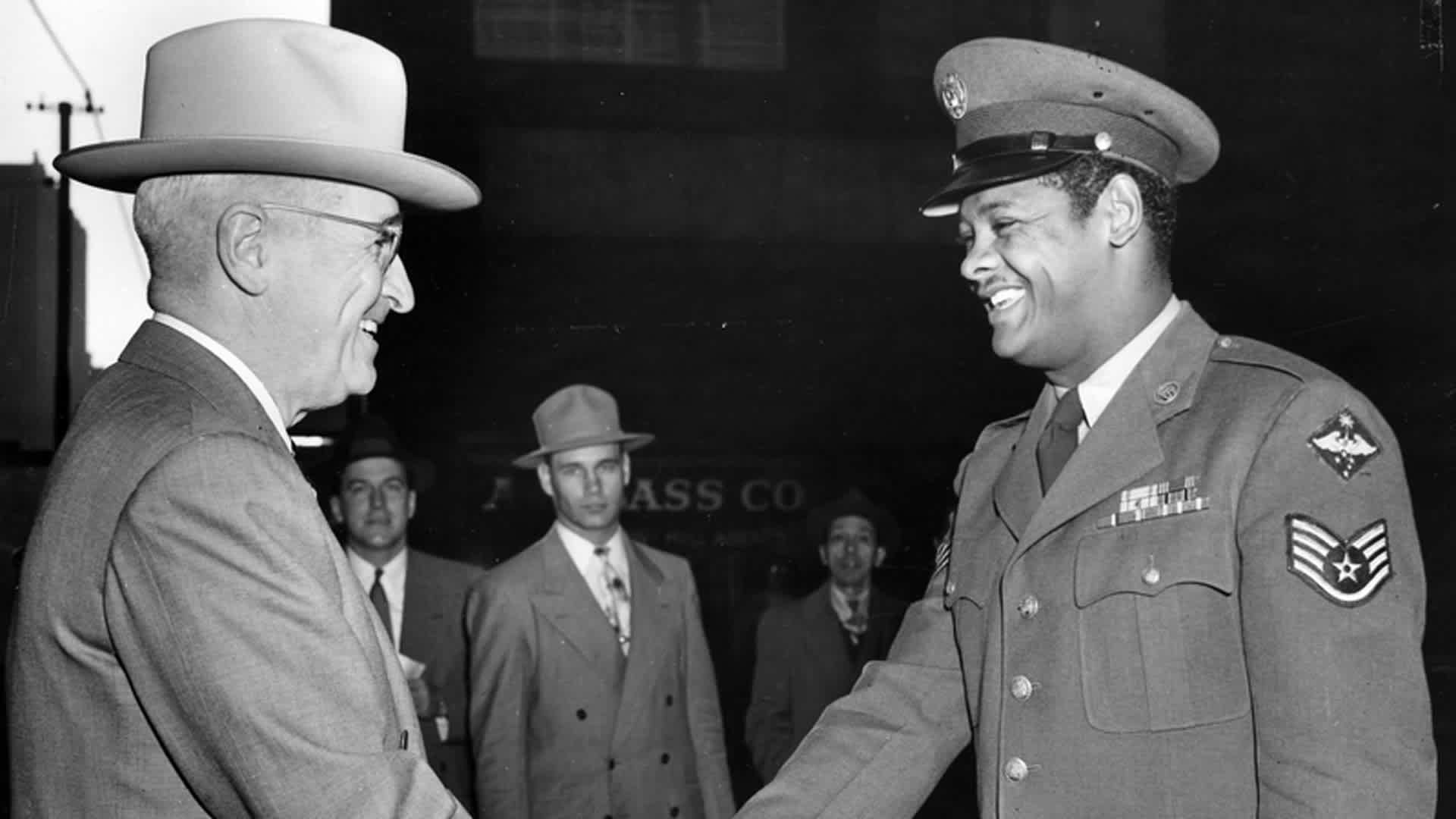 United States Air Force Staff Sergeant Edward Williams (right) of St. Louis, Missouri, exchanges a handshake with his Commander-in-Chief, President Harry S. Truman