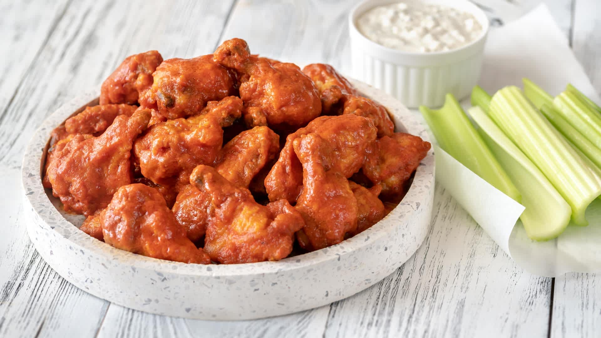 Bowl of buffalo wings with blue cheese dip, Romania - stock photoBowl of buffalo wings with blue cheese dip on the wooden backround