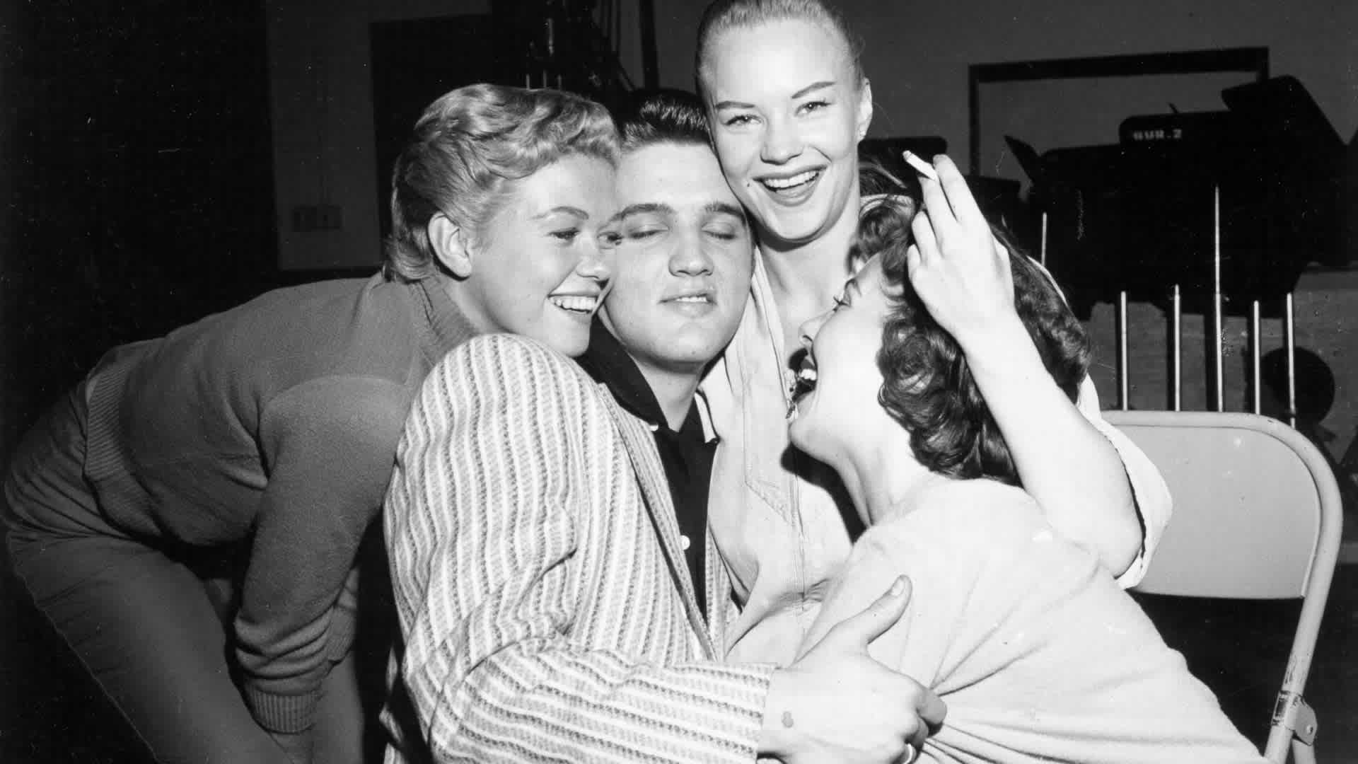 Rock and roll musician Elvis Presley gets mobbed by girls backstage of the Milton Berle Show in Burbank, California, 1956. (Credit: Michael Ochs Archives/Getty Images)