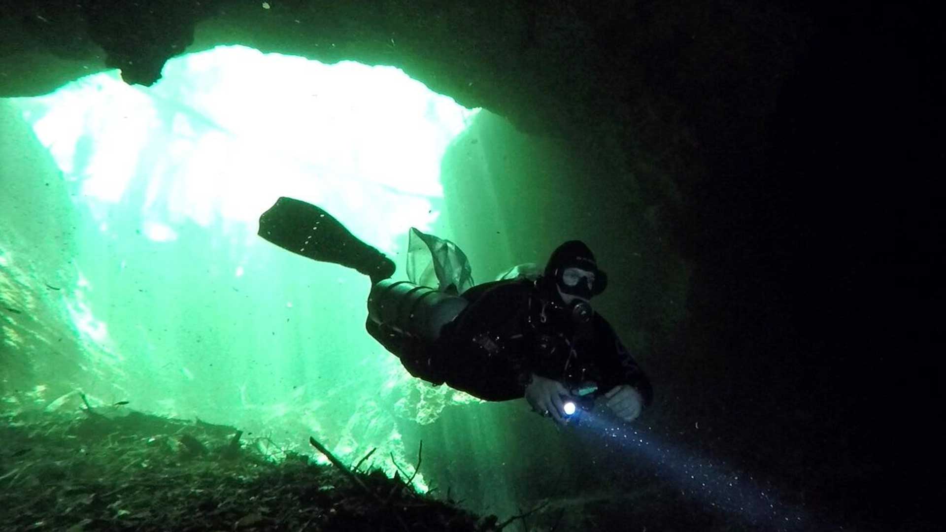 Cave diving scientist John Pohlman (USGS) enters a cave in the Yucatan Peninsula.