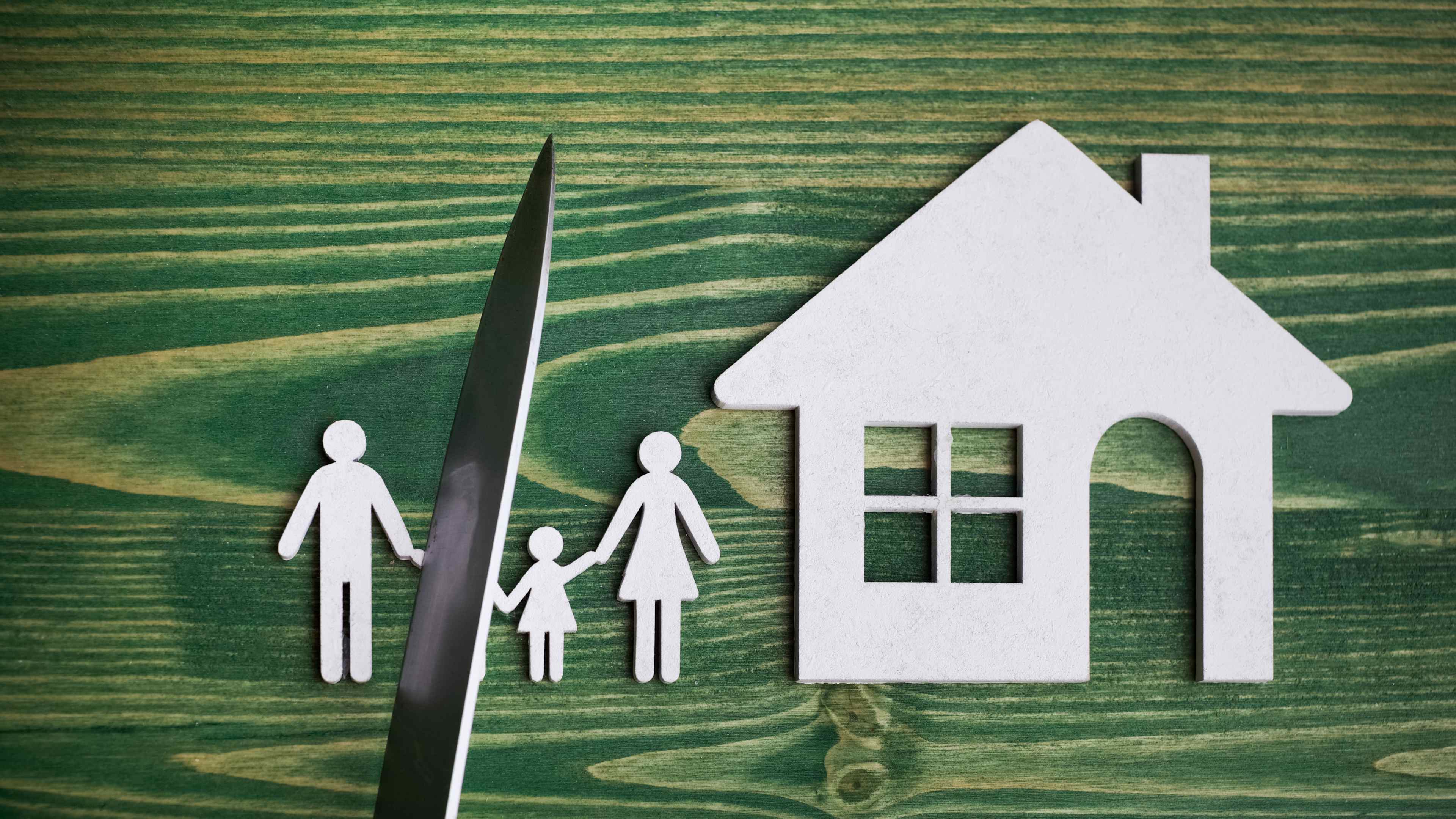 knife divides the whole family. divorce idea. wooden figure. wood background.