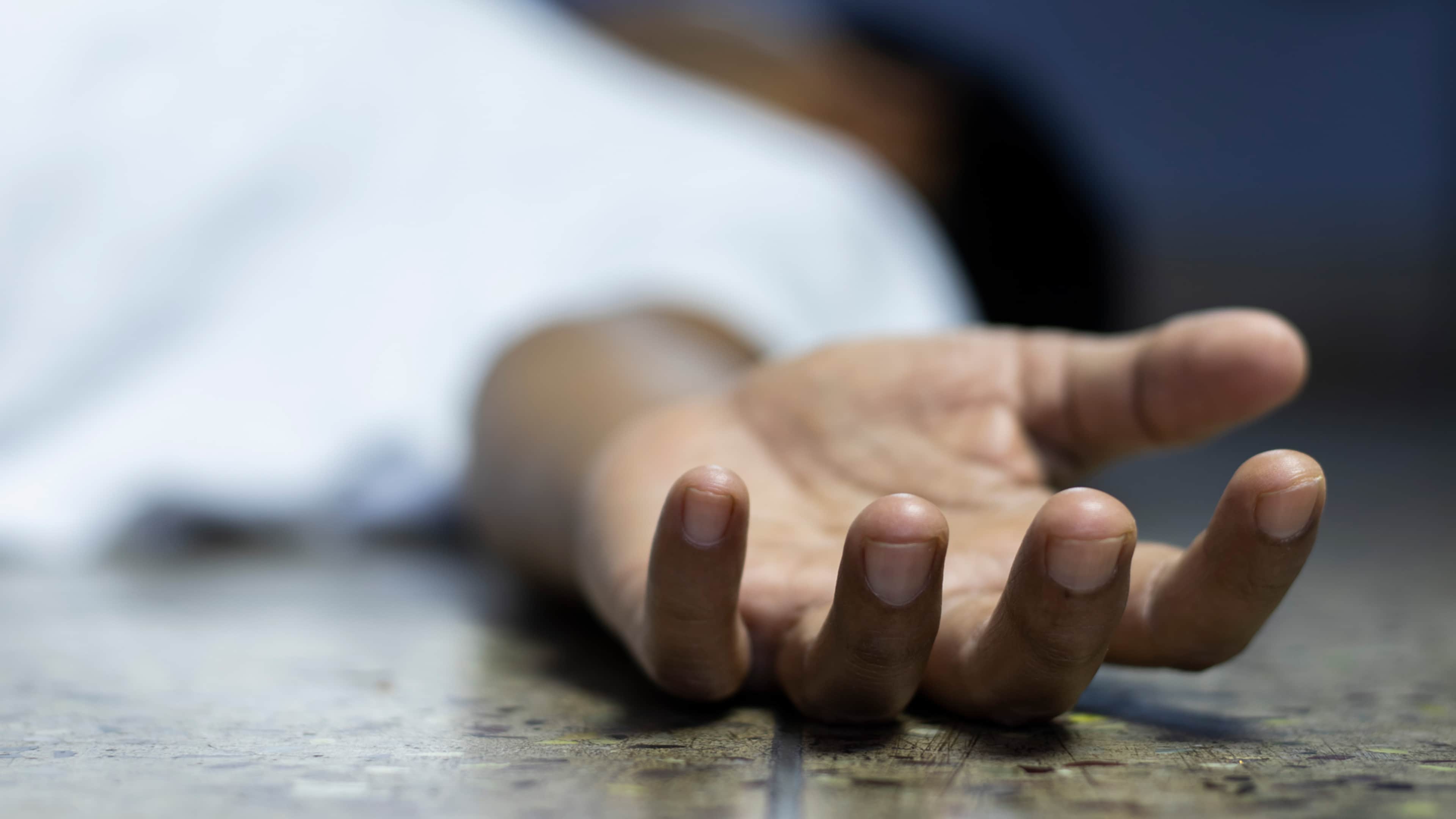 A close-up view of a person's hand reaching out on a textured surface, with a blurred background.