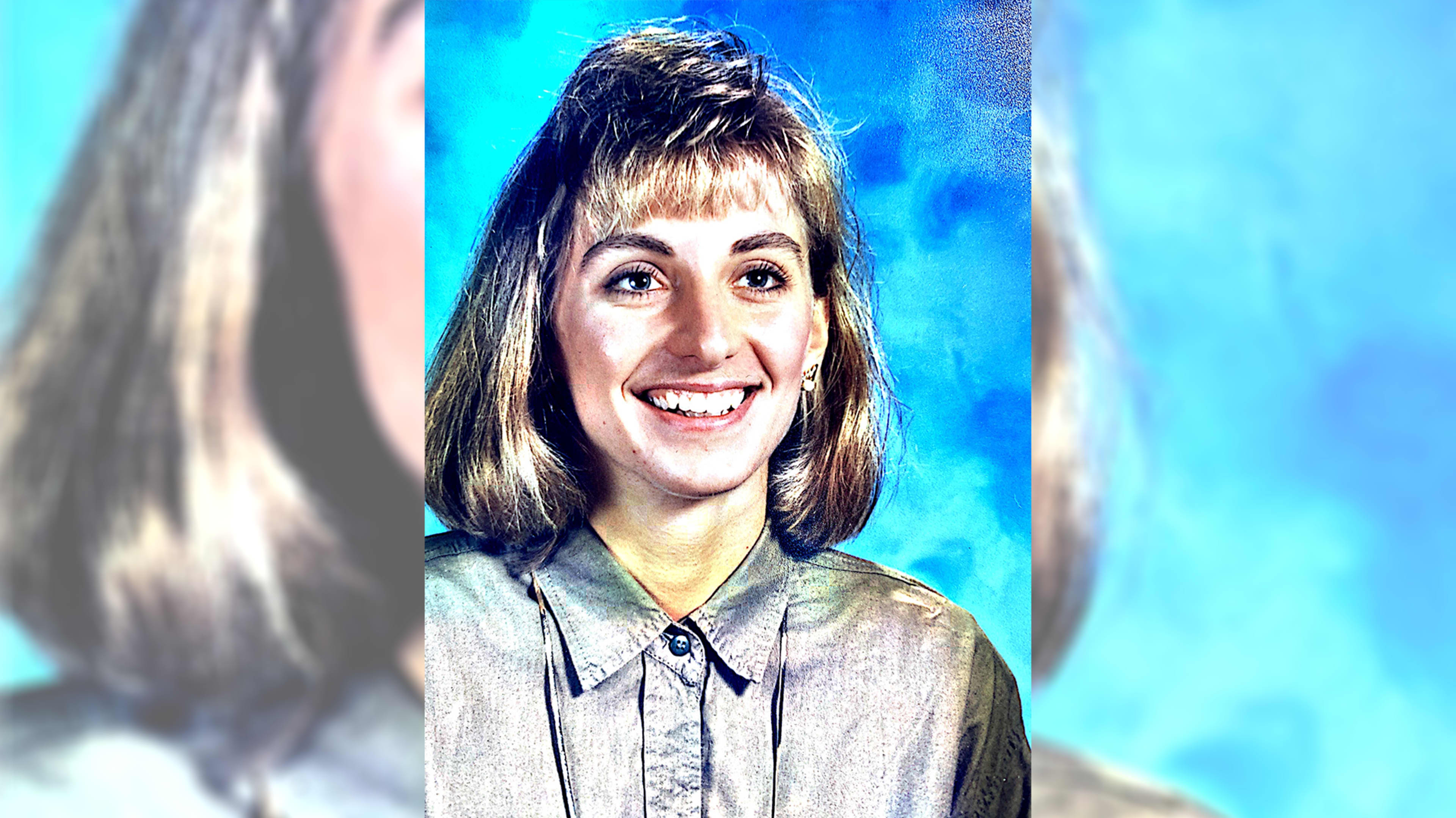 A smiling woman with a bouffant hairstyle appears against a vibrant blue background.