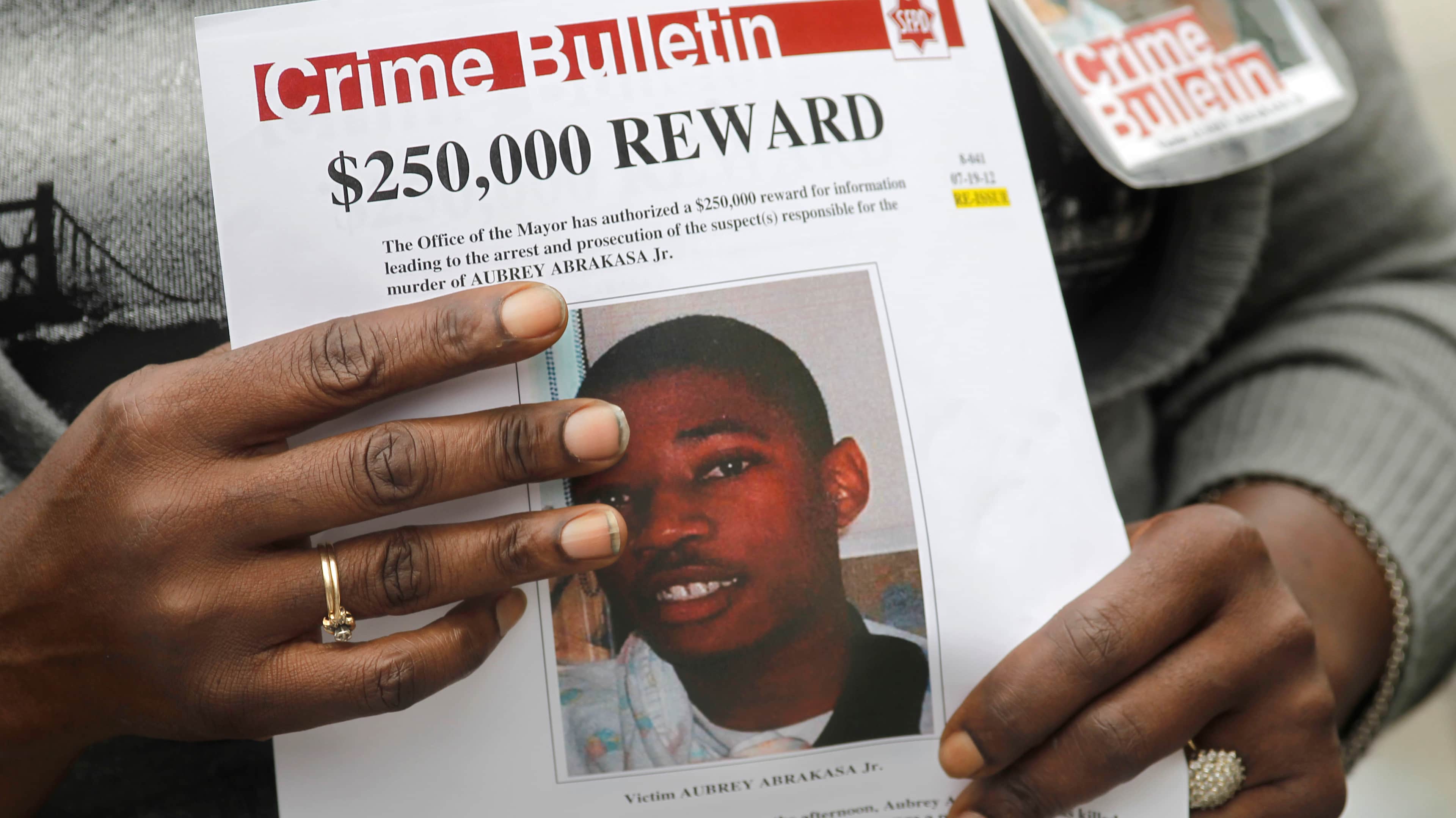 The mother of Aubrey Abrakasa, Paulette Brown clutches a flyer at the corner of Baker and Grove Streets, in San Francisco, Calif., on Tuesday August 14, 2012.  San Francisco Police homicide Inspectors are seeking assistance in solving the murder of Aubrey
