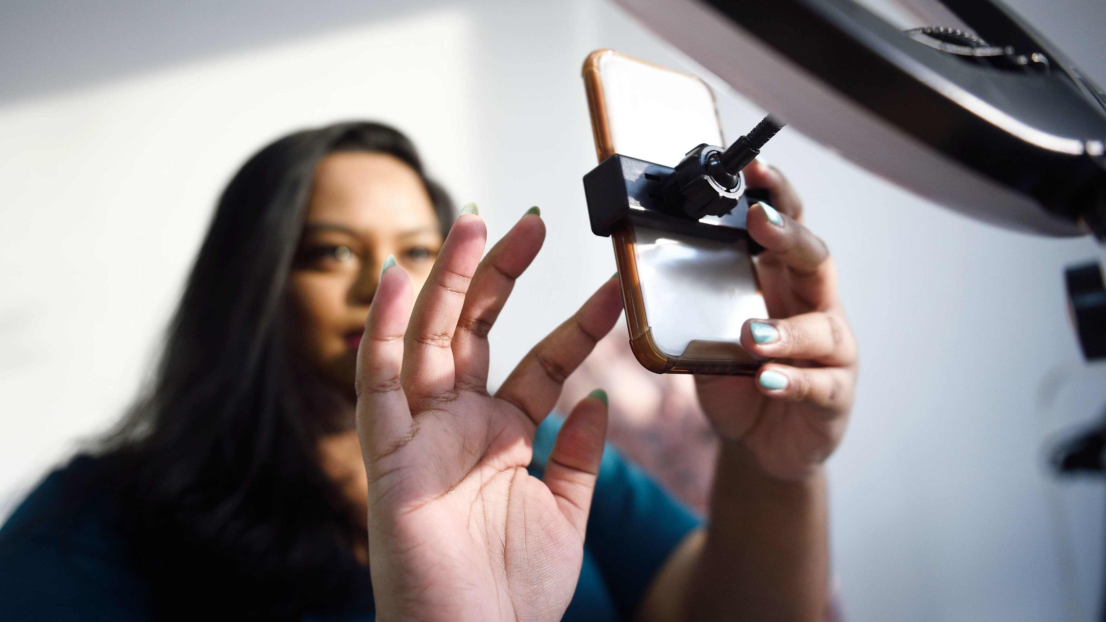 Woman setting up a mobile phone and ring light
