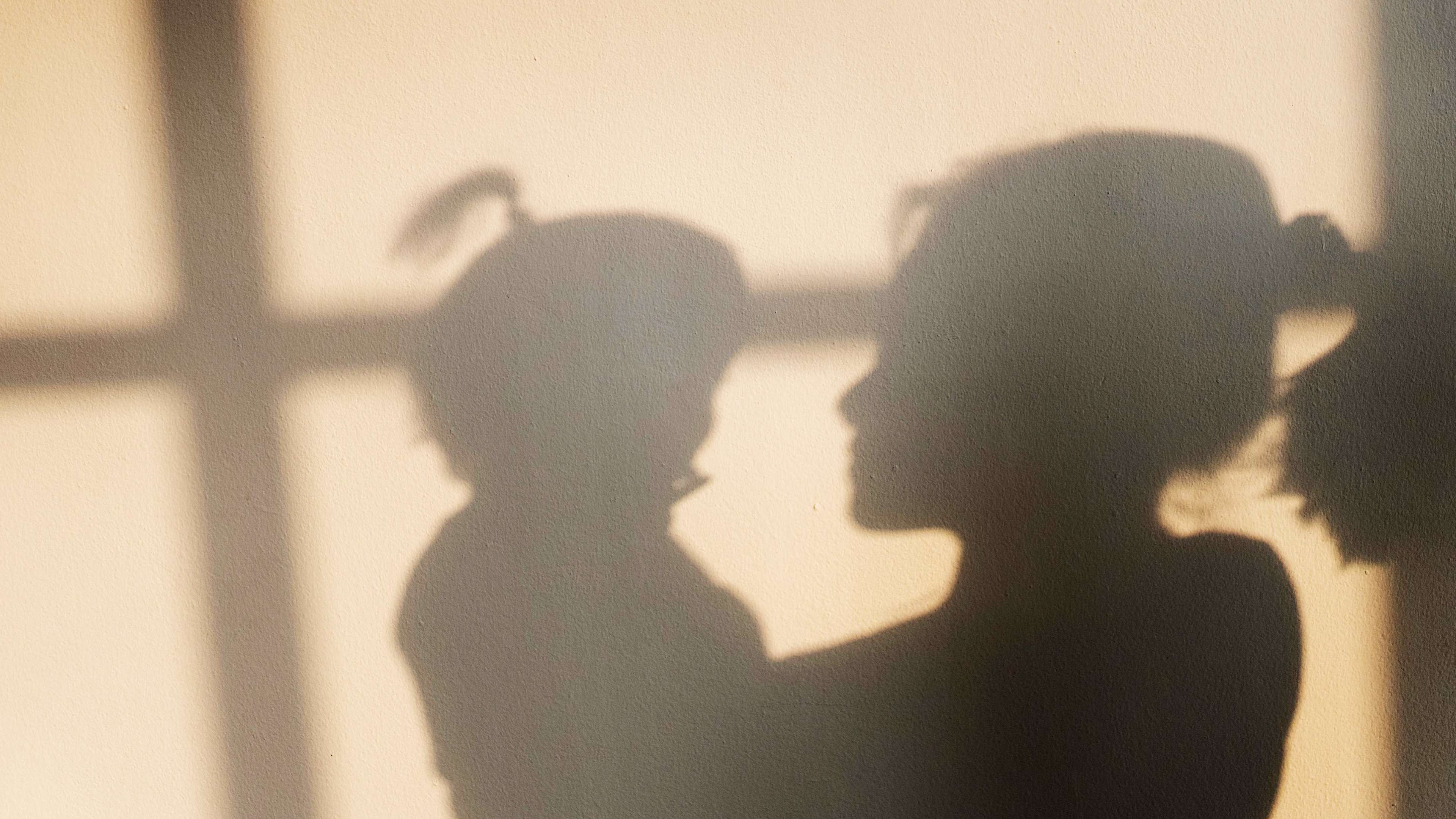 Shadow of mother and daughter on the wall