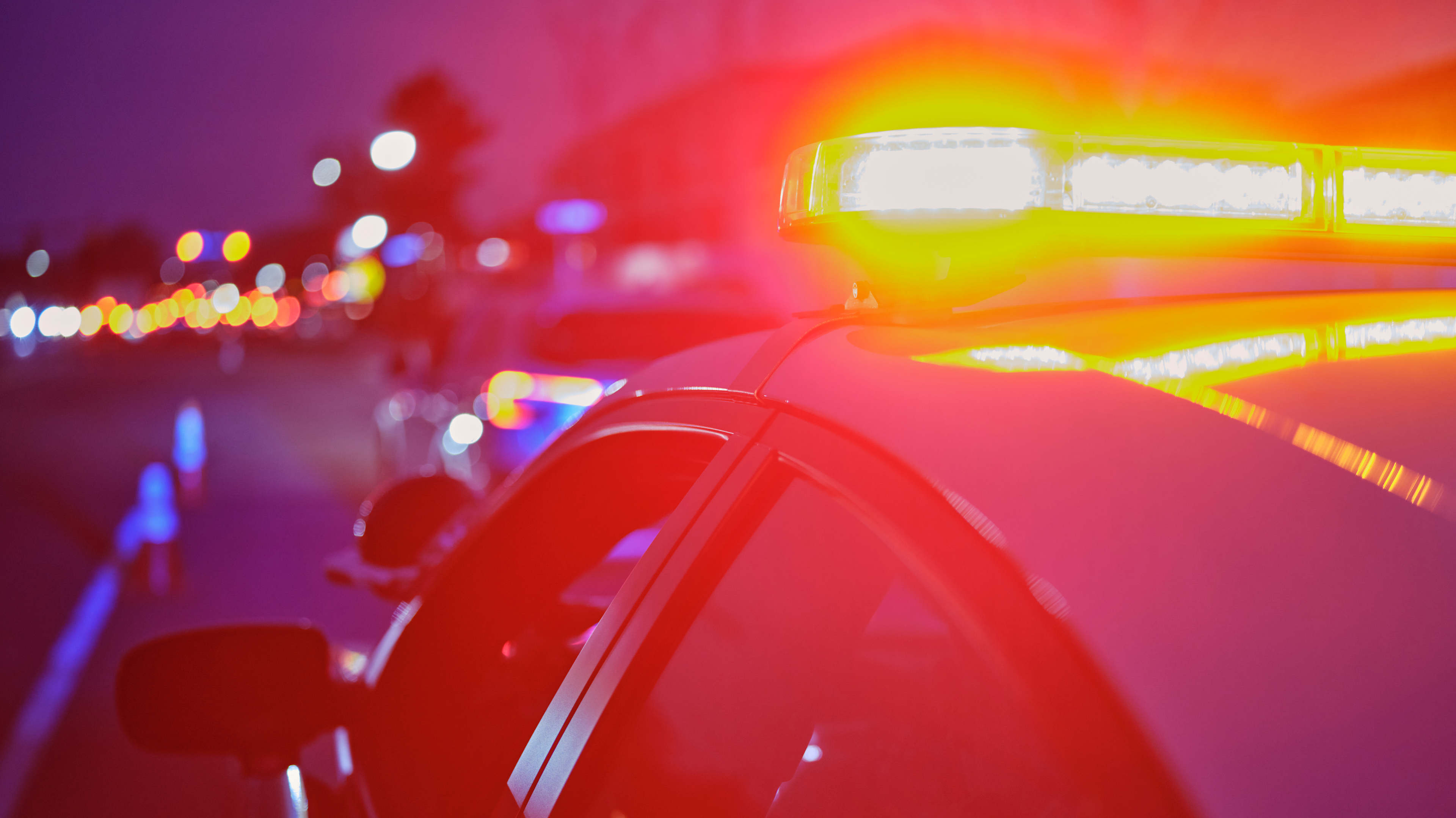 Police Car Stopped on a Road at Night with Emergency Lights