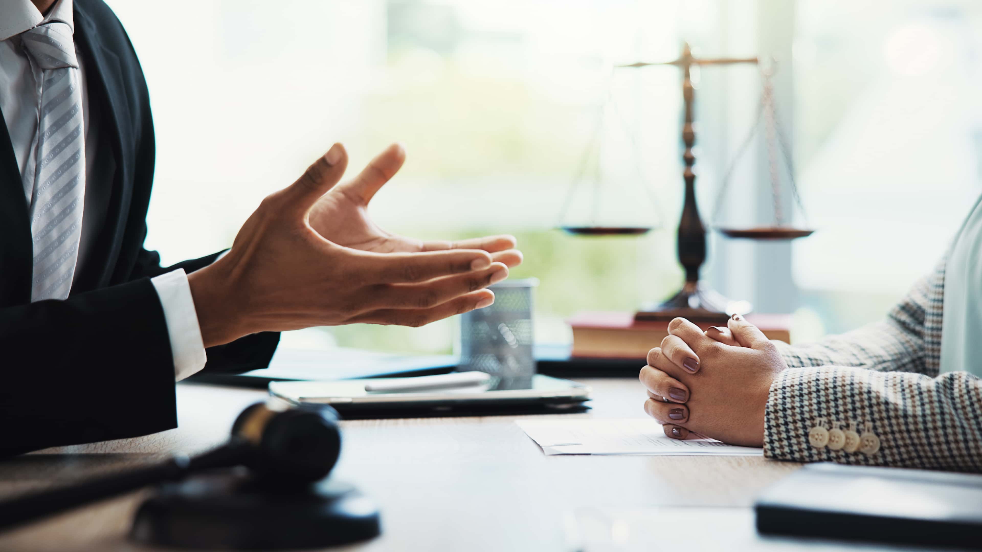 Meeting, lawyers and hands of business people in office for legal consultation, contract and discussion. Corporate, professional and workers with gavel for legislation, agreement and deal at law firm