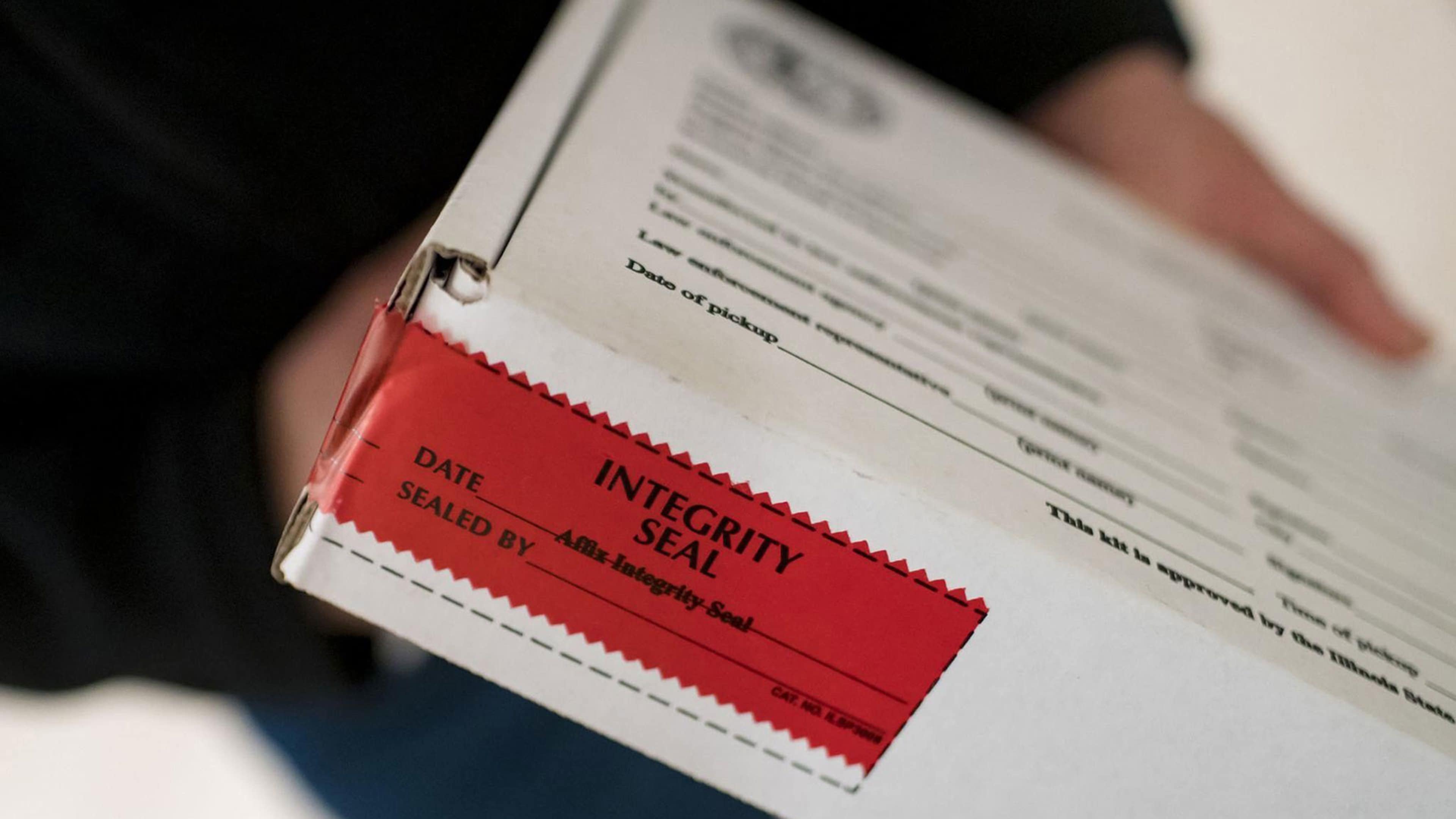 The image shows a close-up of a red security tag attached to a document, with the background blurred.