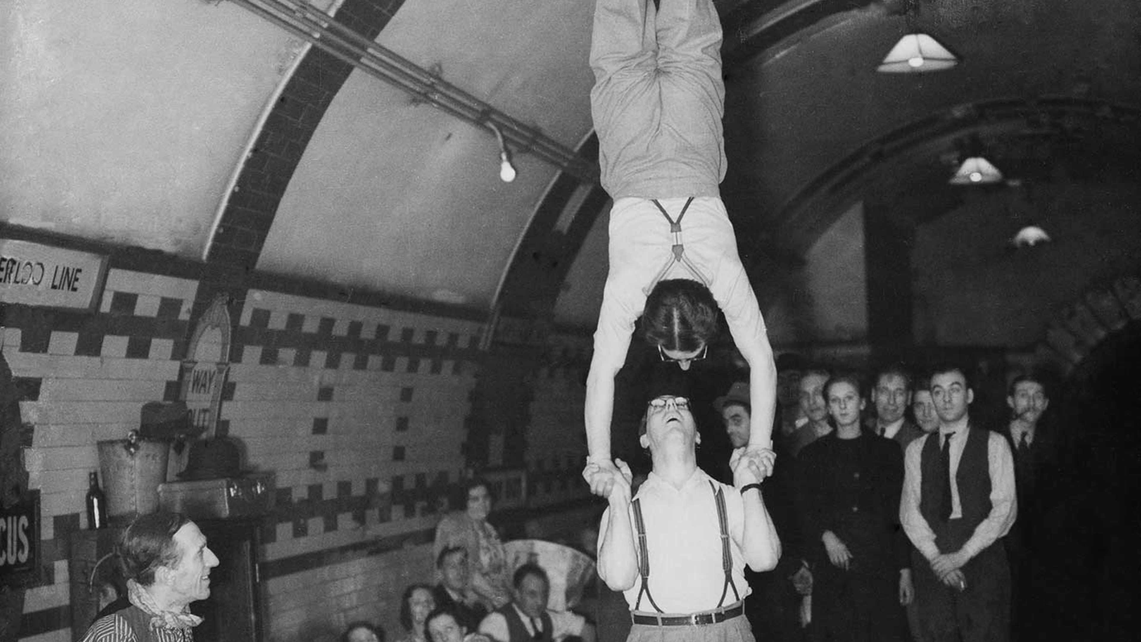 Acrobats perform for a crowd in the London Underground during the Blitz.