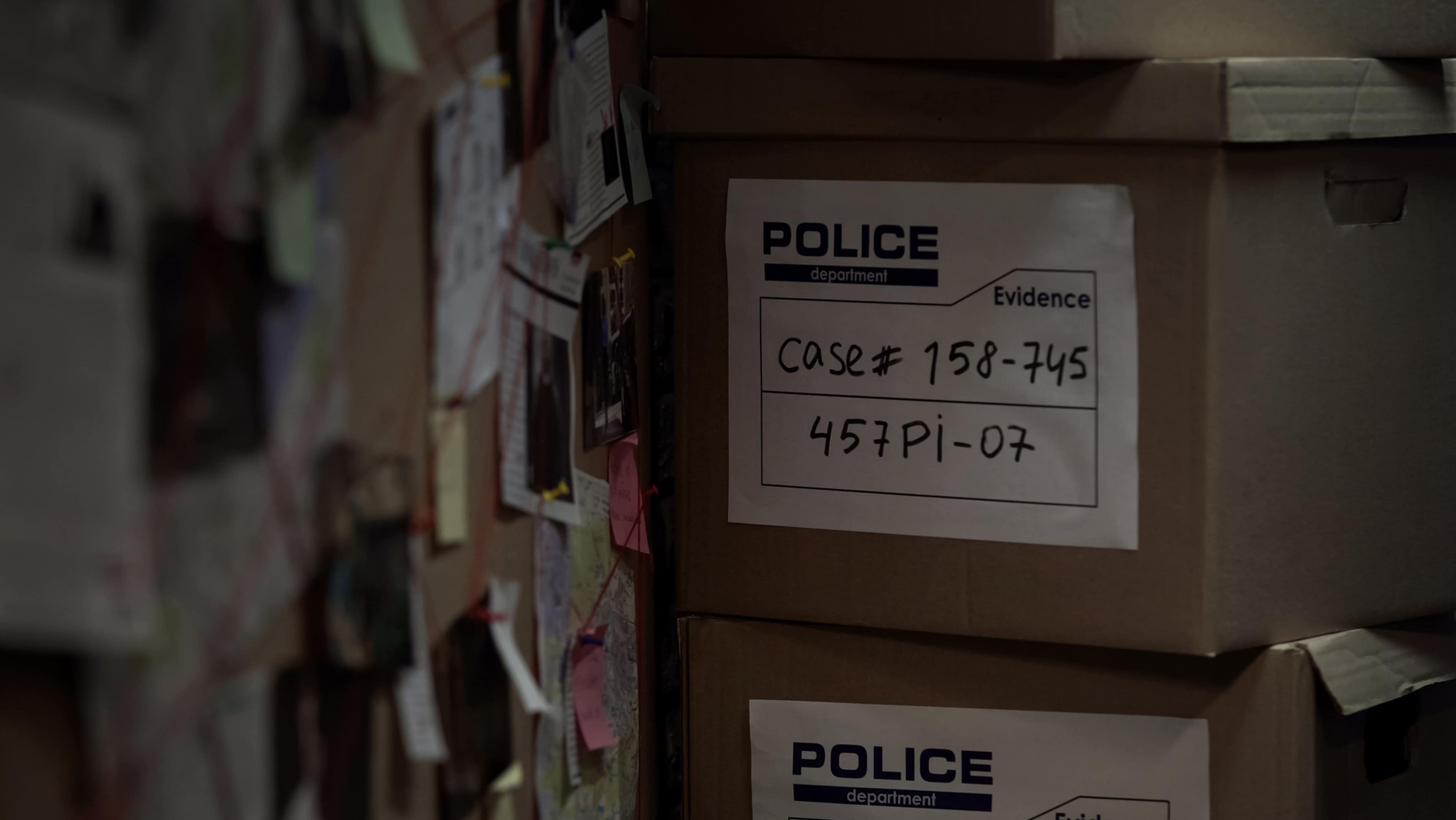 The image shows several cardboard boxes labeled "POLICE" with evidence tags and case numbers on them, suggesting they contain evidence or items related to a police investigation.