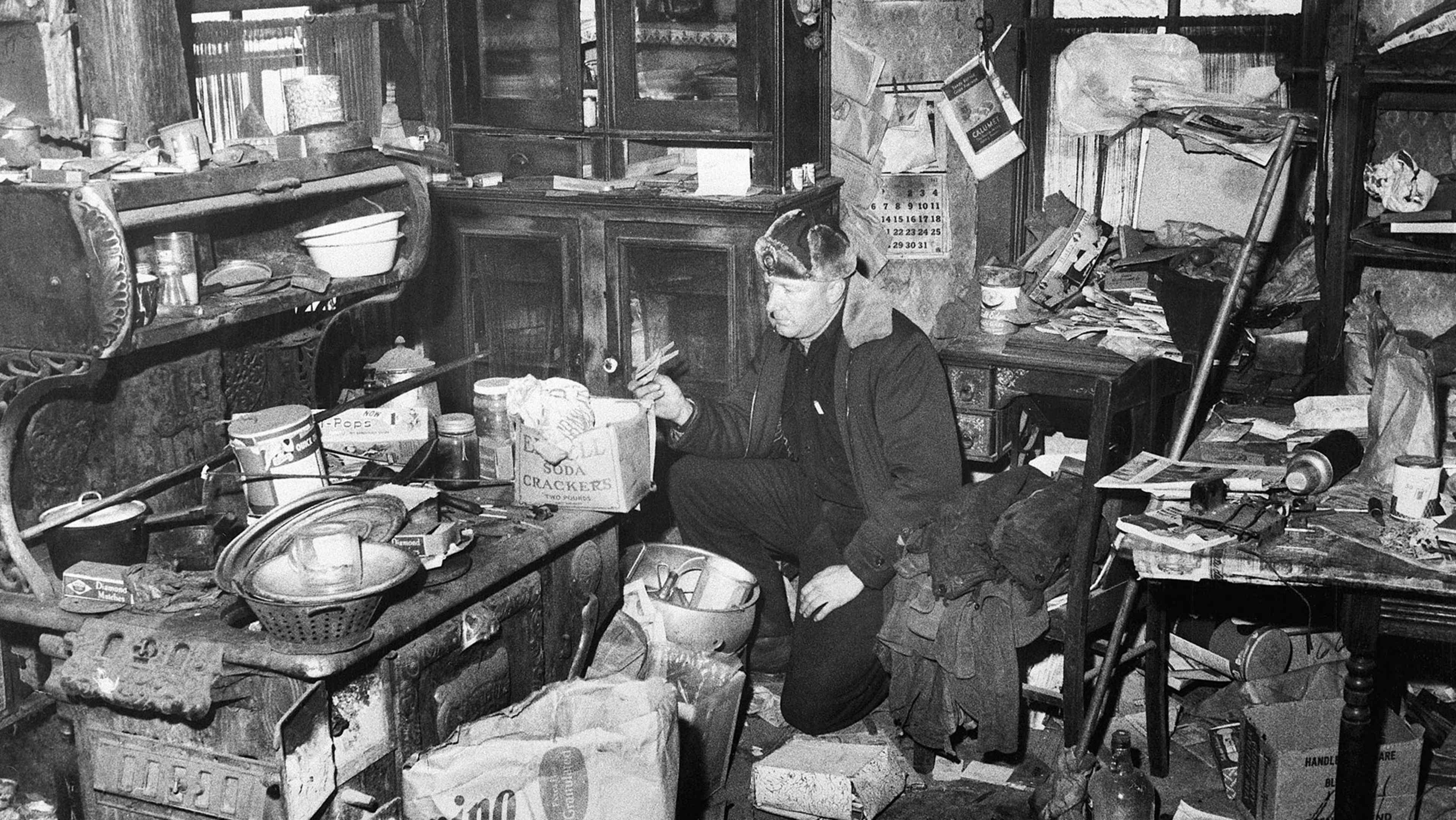 A cluttered and disorganized interior space filled with various items, including furniture, boxes, and other miscellaneous objects, creating an overwhelming and chaotic atmosphere.