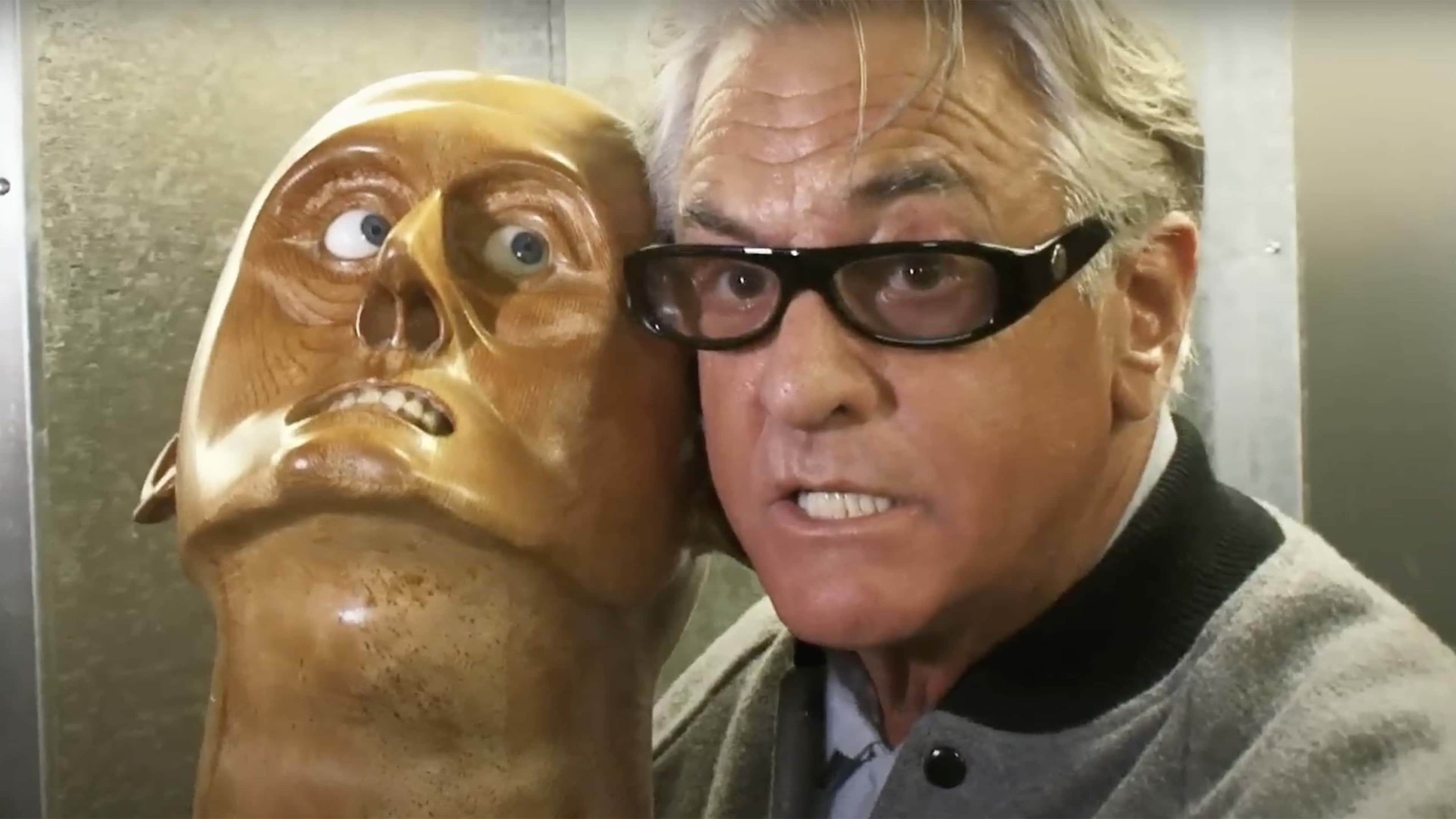 Barry from Storage Wars holds up a sculpture of a head while attempting to recreate its unusual facial expression.