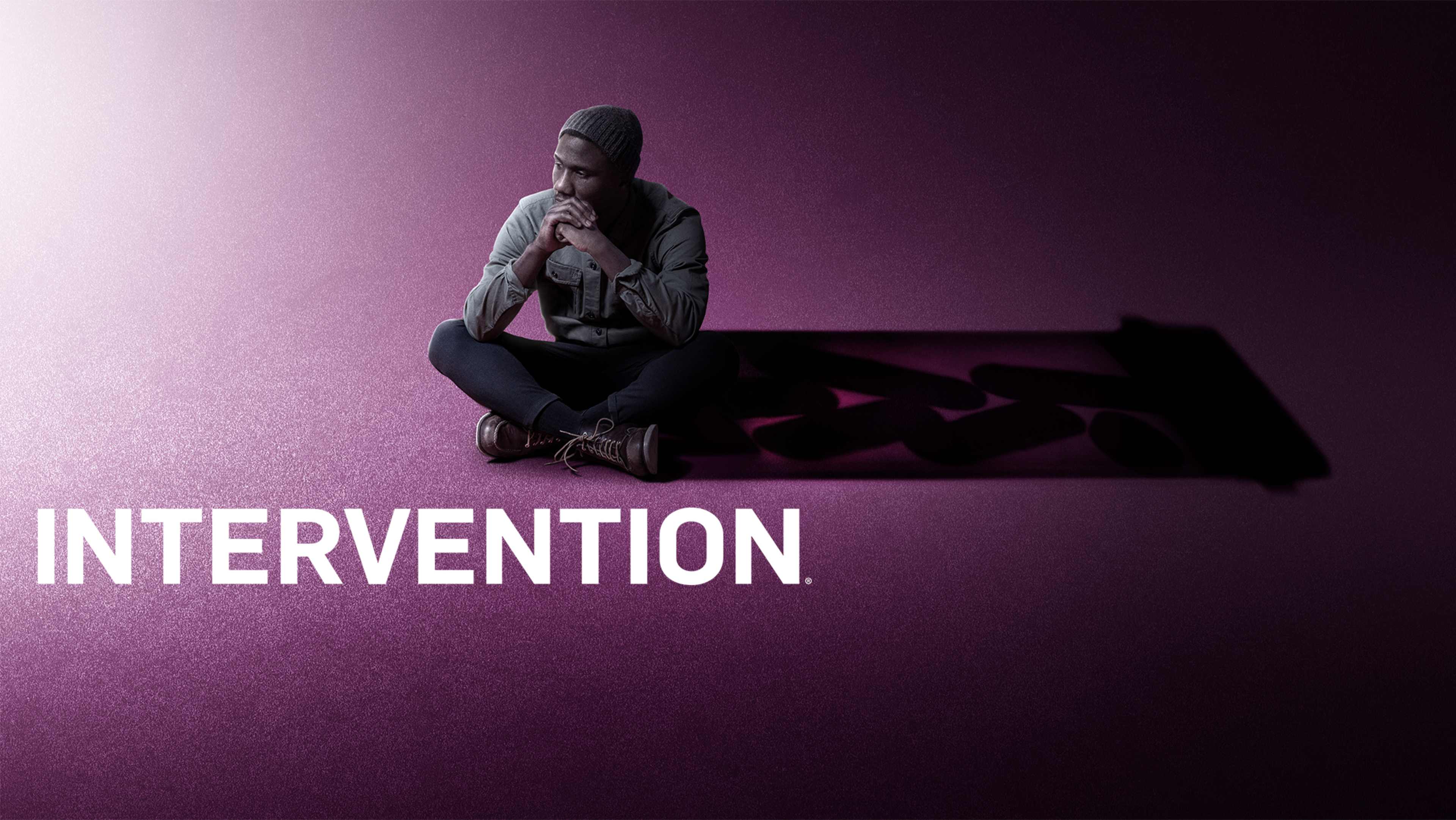 A person in a hooded jacket sits on the floor against a dark purple background, with the word "INTERVENTION" prominently displayed.
