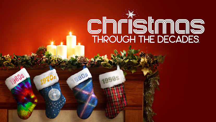 The image depicts Christmas stockings from different decades, with the text "Christmas Through the Decades" displayed prominently against a warm, fiery background featuring lit candles.
