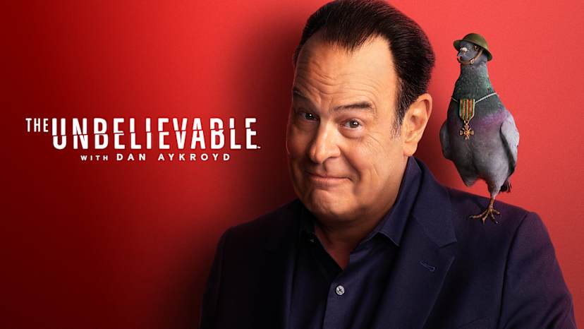 A middle-aged man with a serious expression stands against a vibrant red background, with a small animal perched on his shoulder.