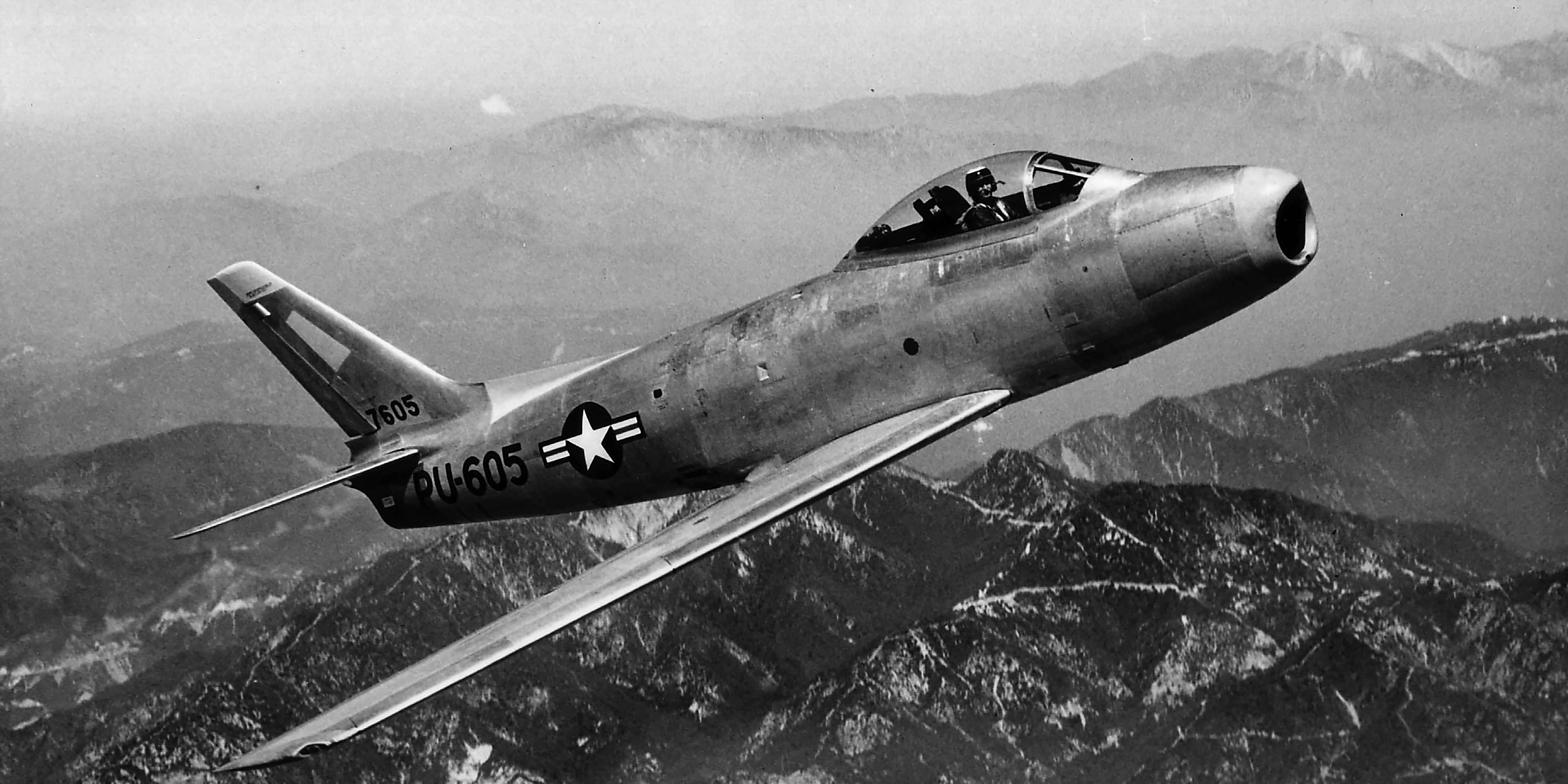 View of an U.S. Air Force F-86A Sabre in flight against a mountainous background, 1951. The first American swept-wing fighter aircraft, the jet countered the Soviet Union's MiG-15 during the Korean War.