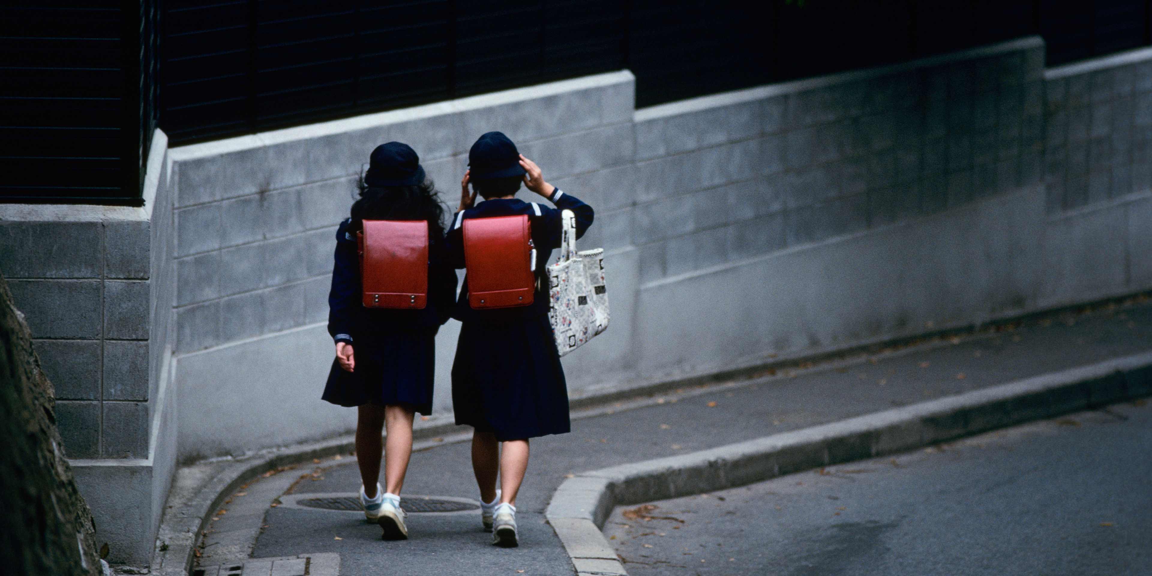 Schoolgirls Walking Along Sidewalk