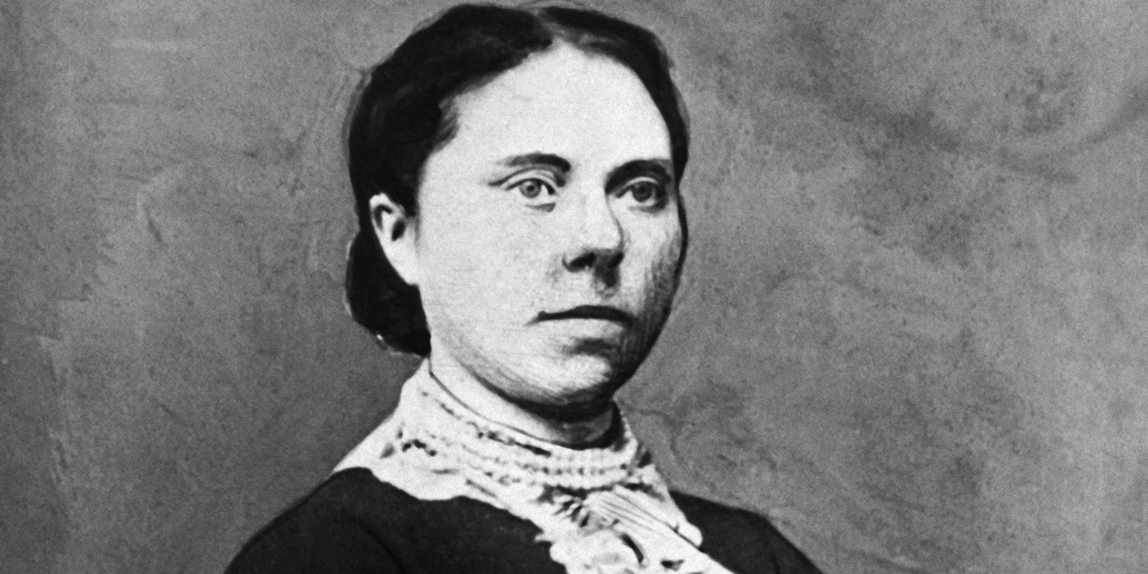 A black and white portrait of a serious-looking woman with dark hair and a lace collar, set against a plain background.