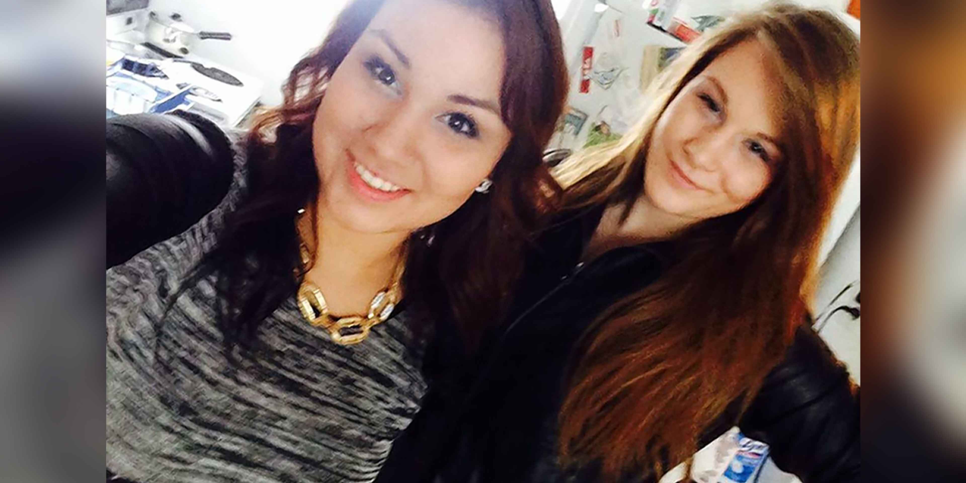 The image shows two young women with long, dark hair and bright smiles, posing together in what appears to be a bedroom or dorm room setting with various personal items and decorations visible in the background.