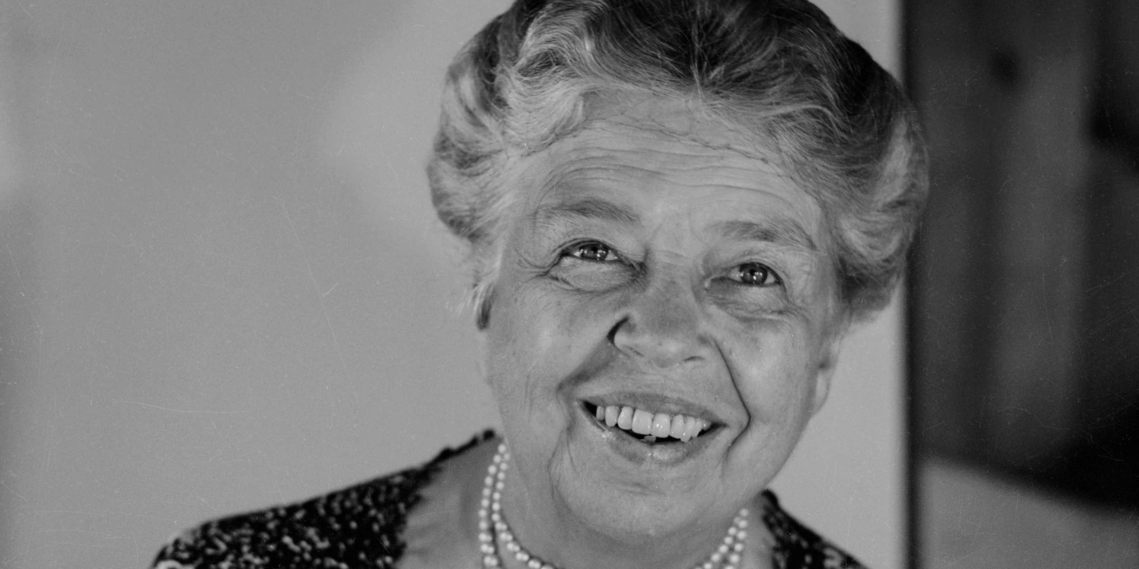 Eleanor Delano Roosevelt, seated, with a wide, warm smile