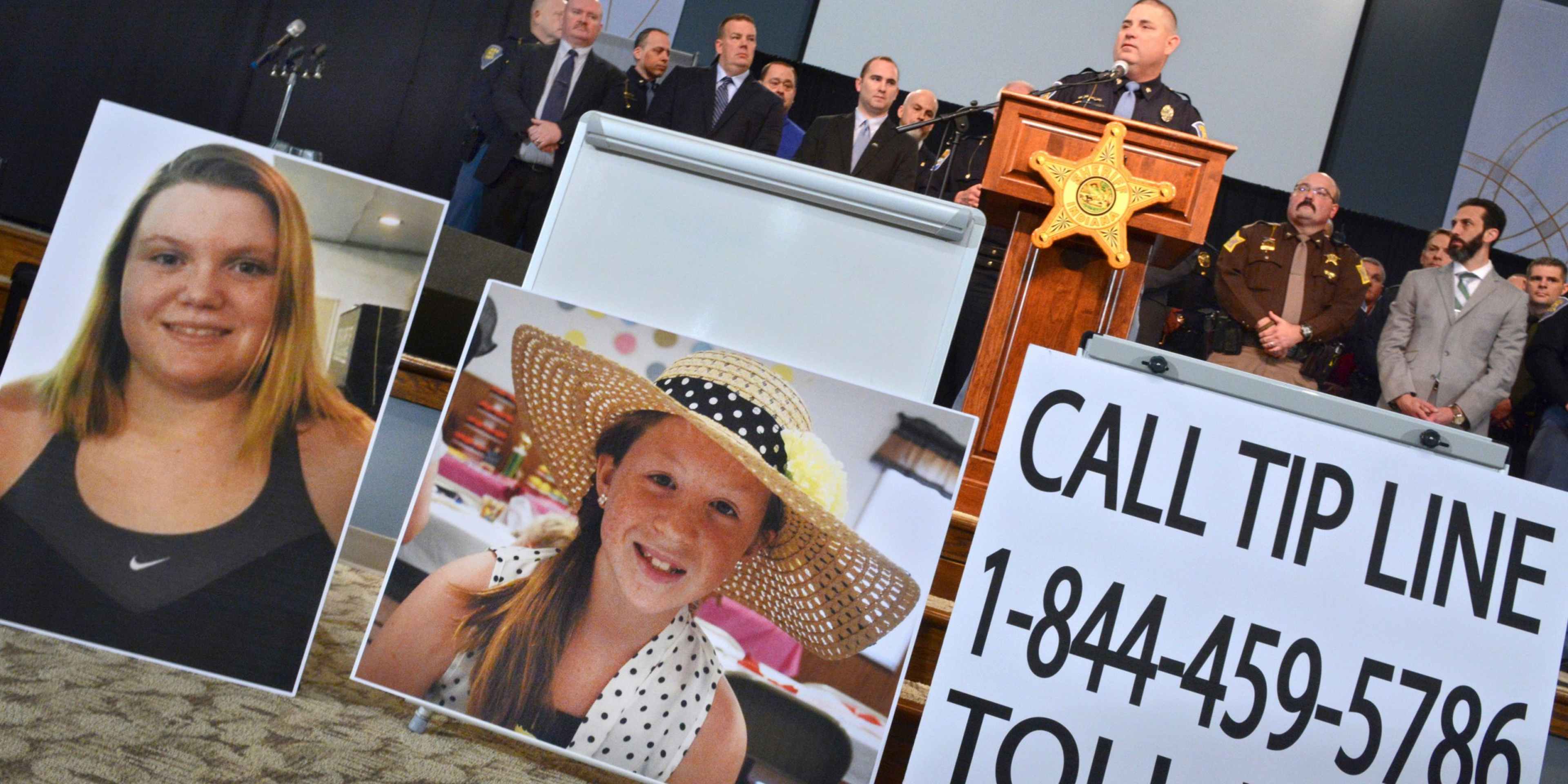 The image shows a display with photographs of two young women, along with a sign displaying a toll-free phone number for a "Call Tip Line".