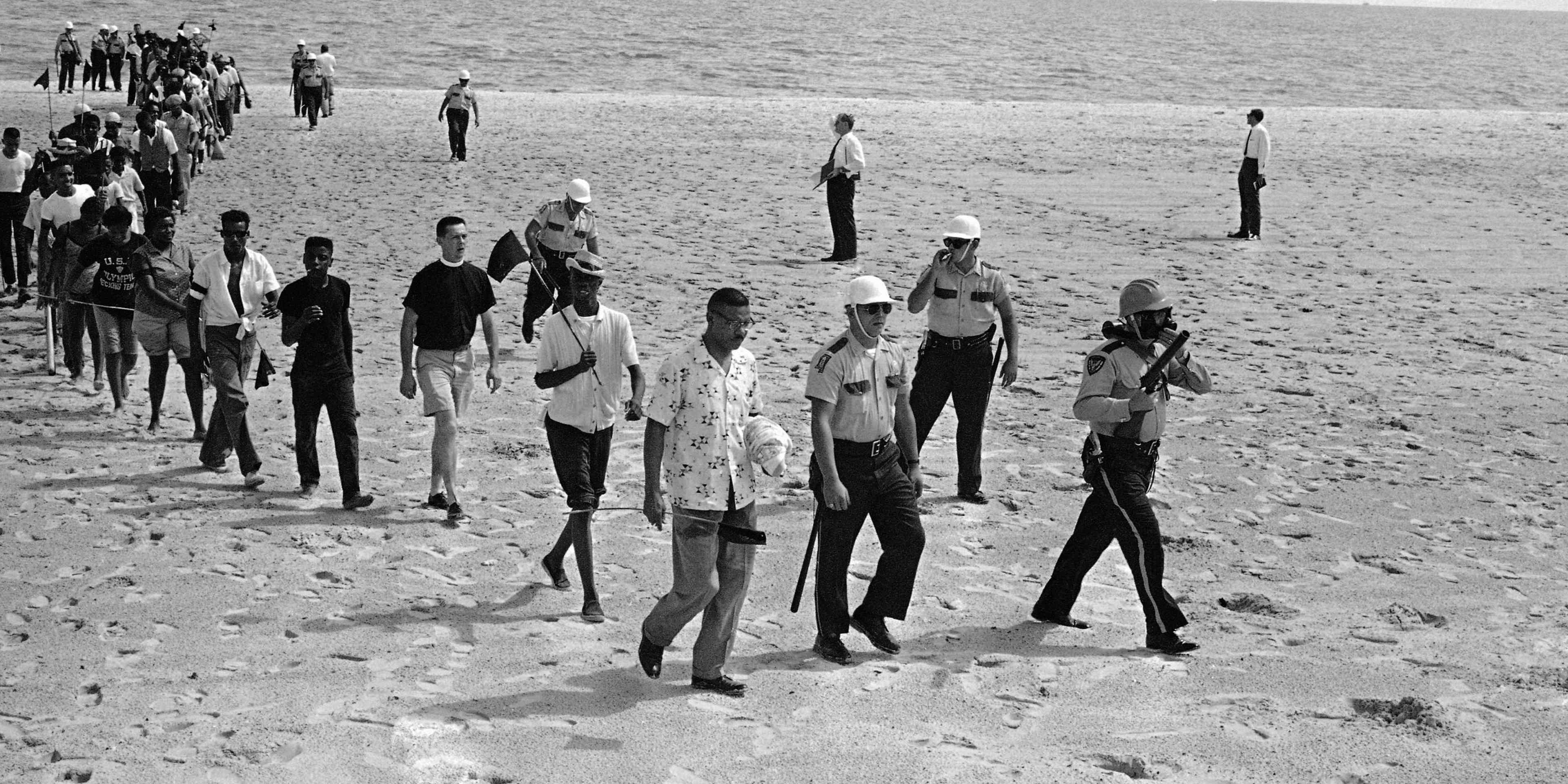 In this June 23, 1963, file photo, Black and white demonstrators, under arrest, walk off the beach at Biloxi, Miss., after staging a wade-in to try to desegregate the Gulf Coast beach