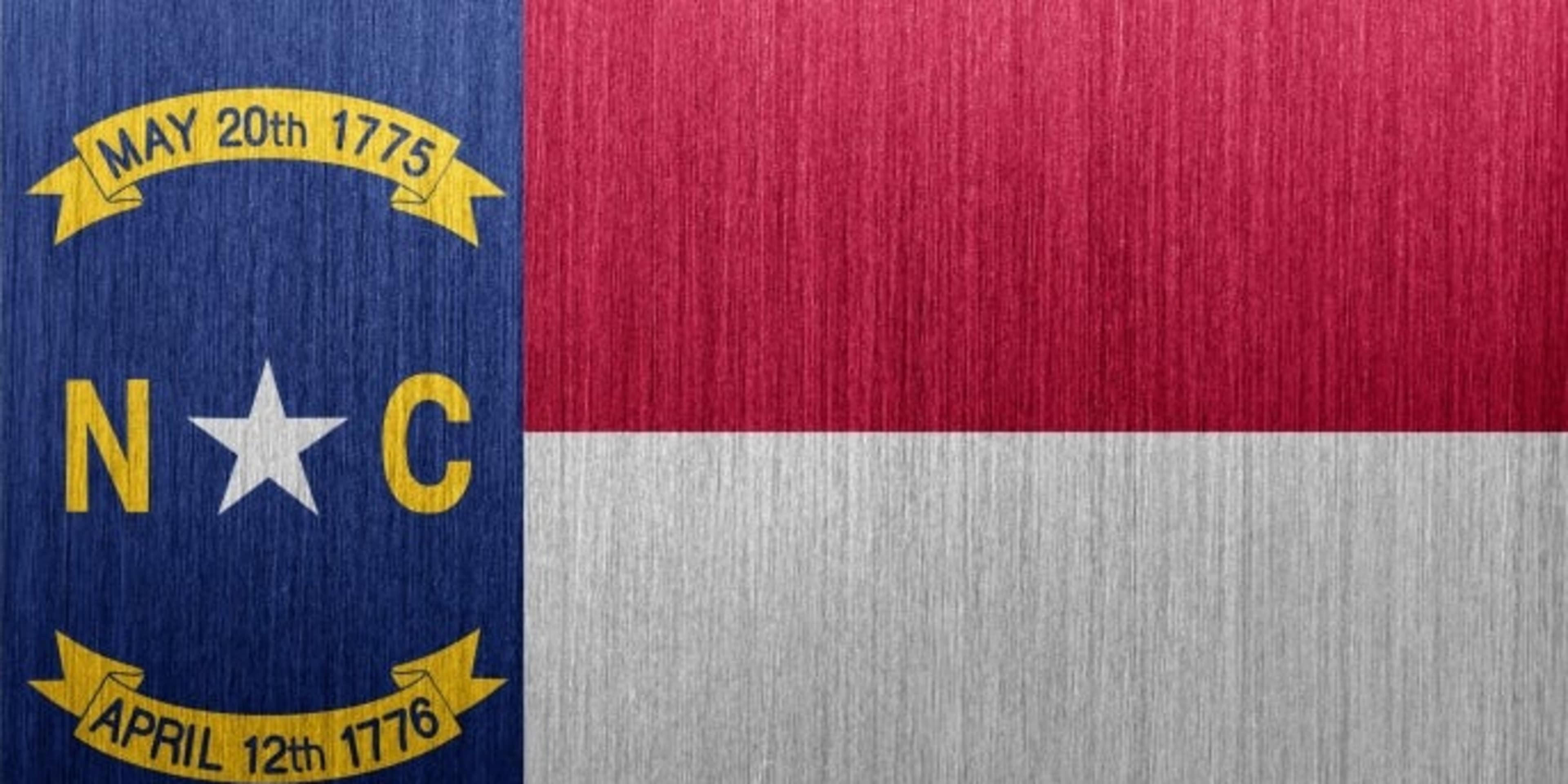 Flag of the US state of North Carolina on a brushed metal backgound