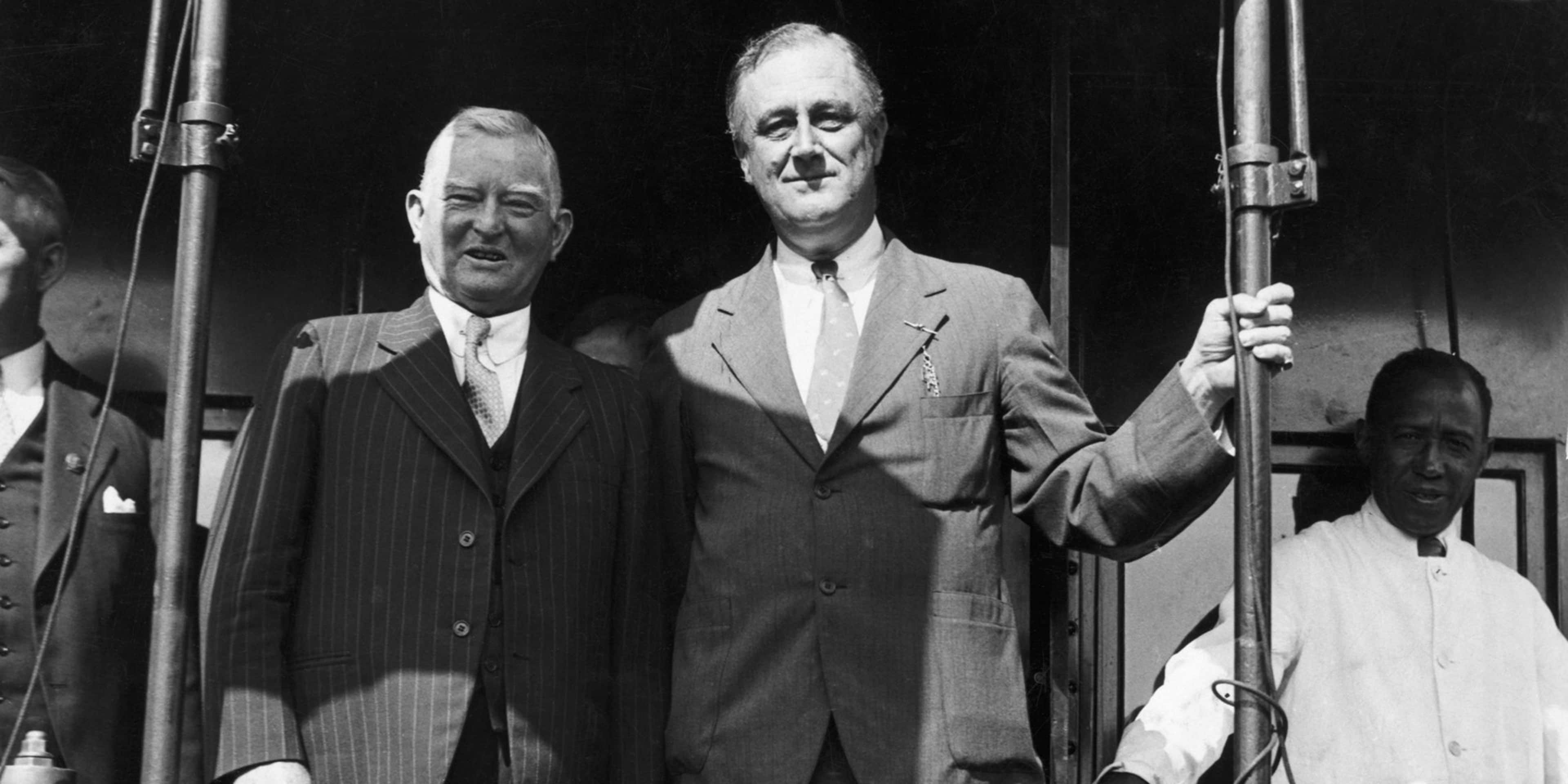 Vice presidential candidate John Nance Garner stands at the back of a special campaign train with presidential candidate Franklin Delano Roosevelt during a stop in Topeka, Kansas.