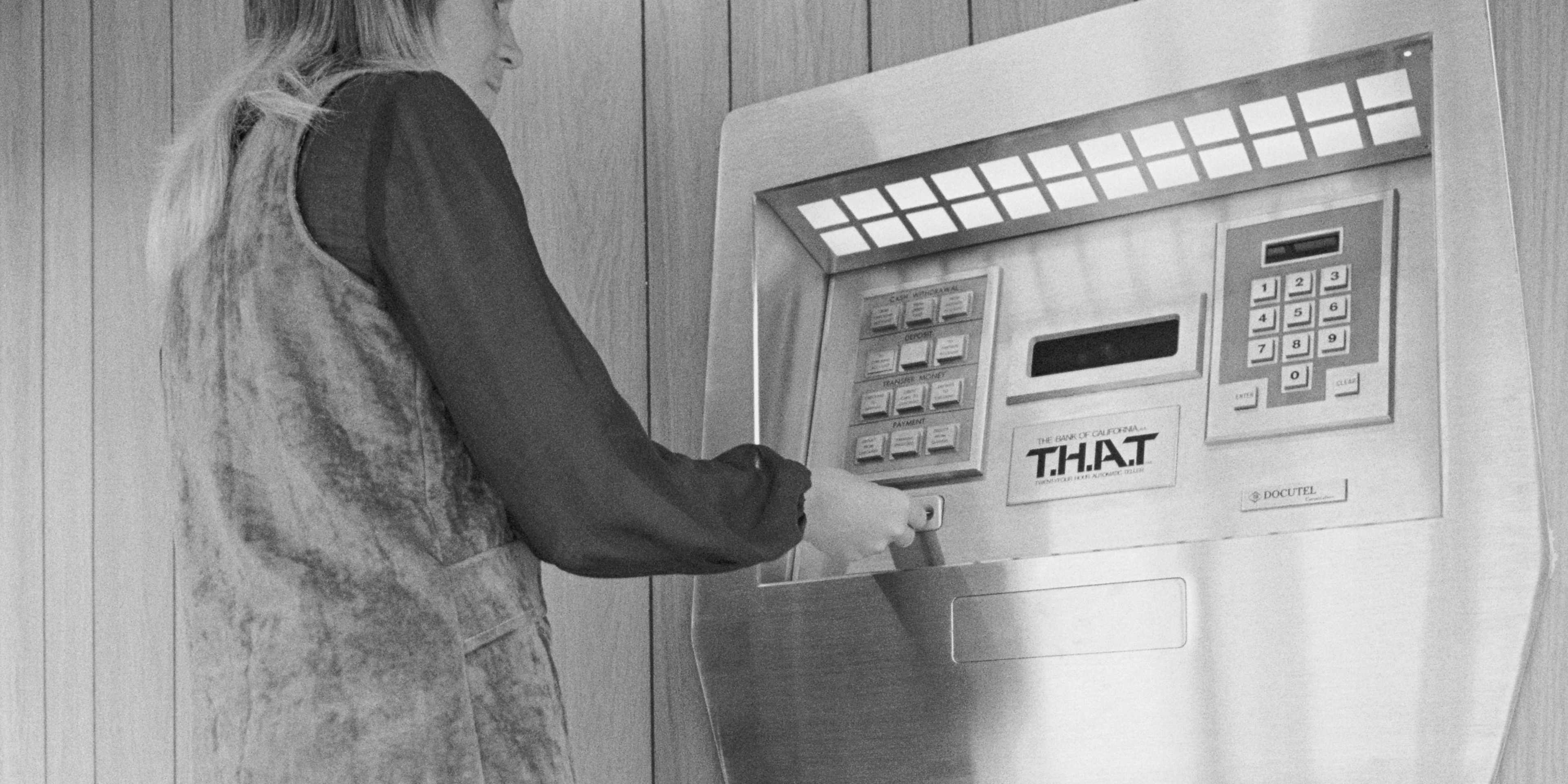 Jaynee Hurd demonstrates the first automated teller machine at the Los Angeles branch of the Bank of California. Named "THAT", which stands for twenty-four hour automatic teller, the machine can perform ninety-five percent of the functions of a teller when operated by the bank's clients.